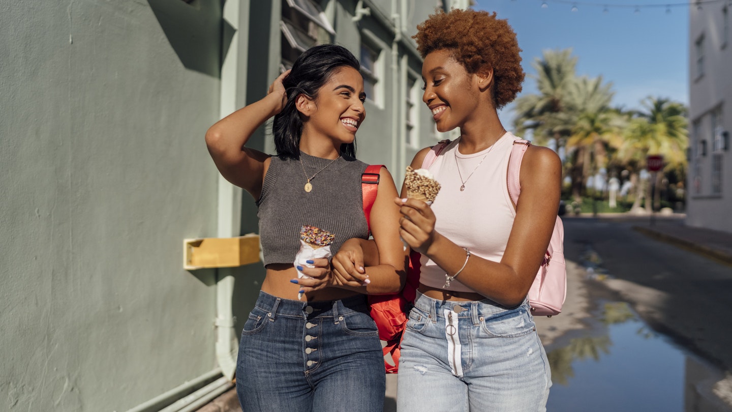 Two women smiling and eating ice cream cones in Miami Beach, Florida