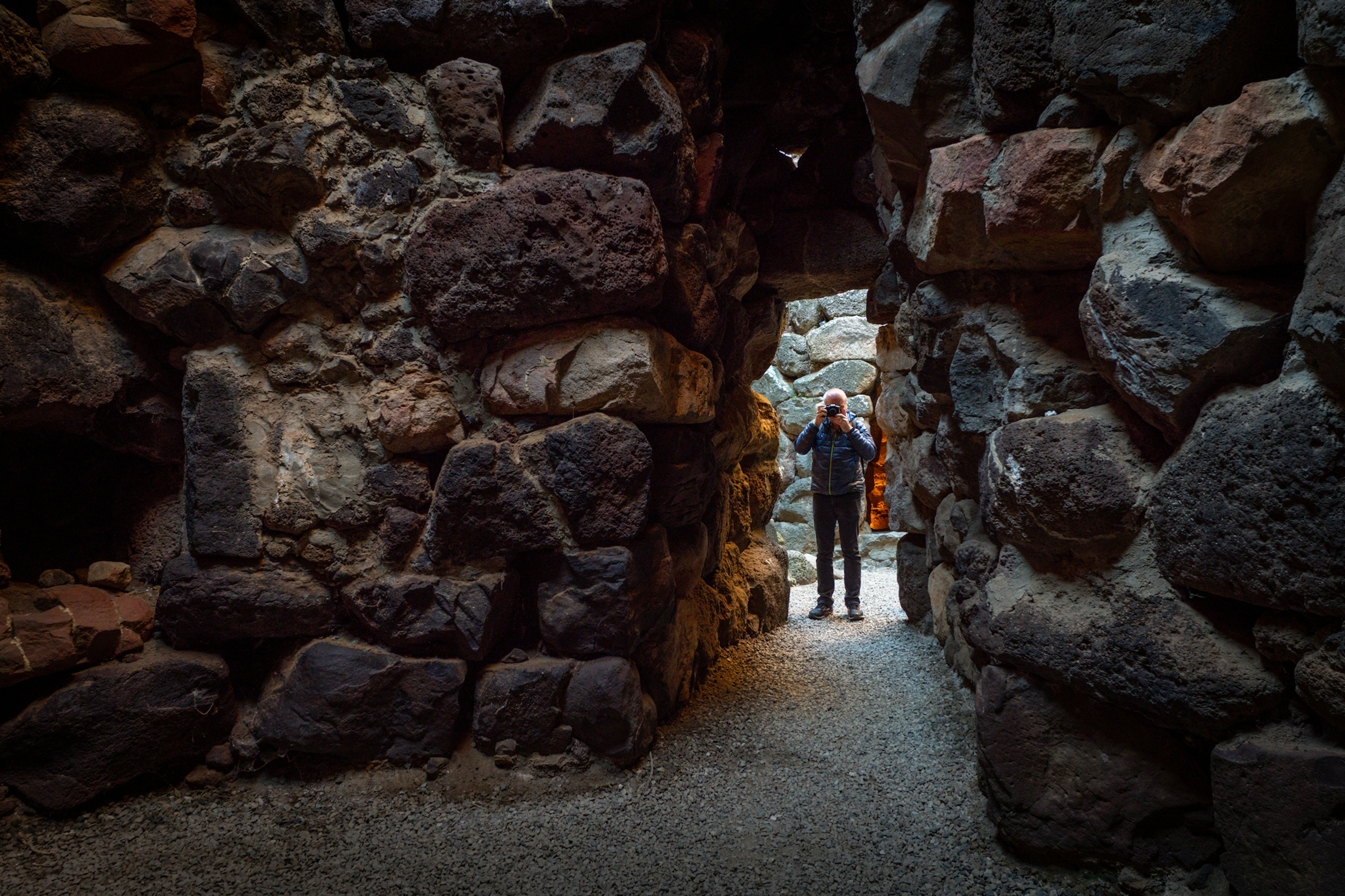 A man taking a photo at the Su Nuraxi Ruins in Sardinia