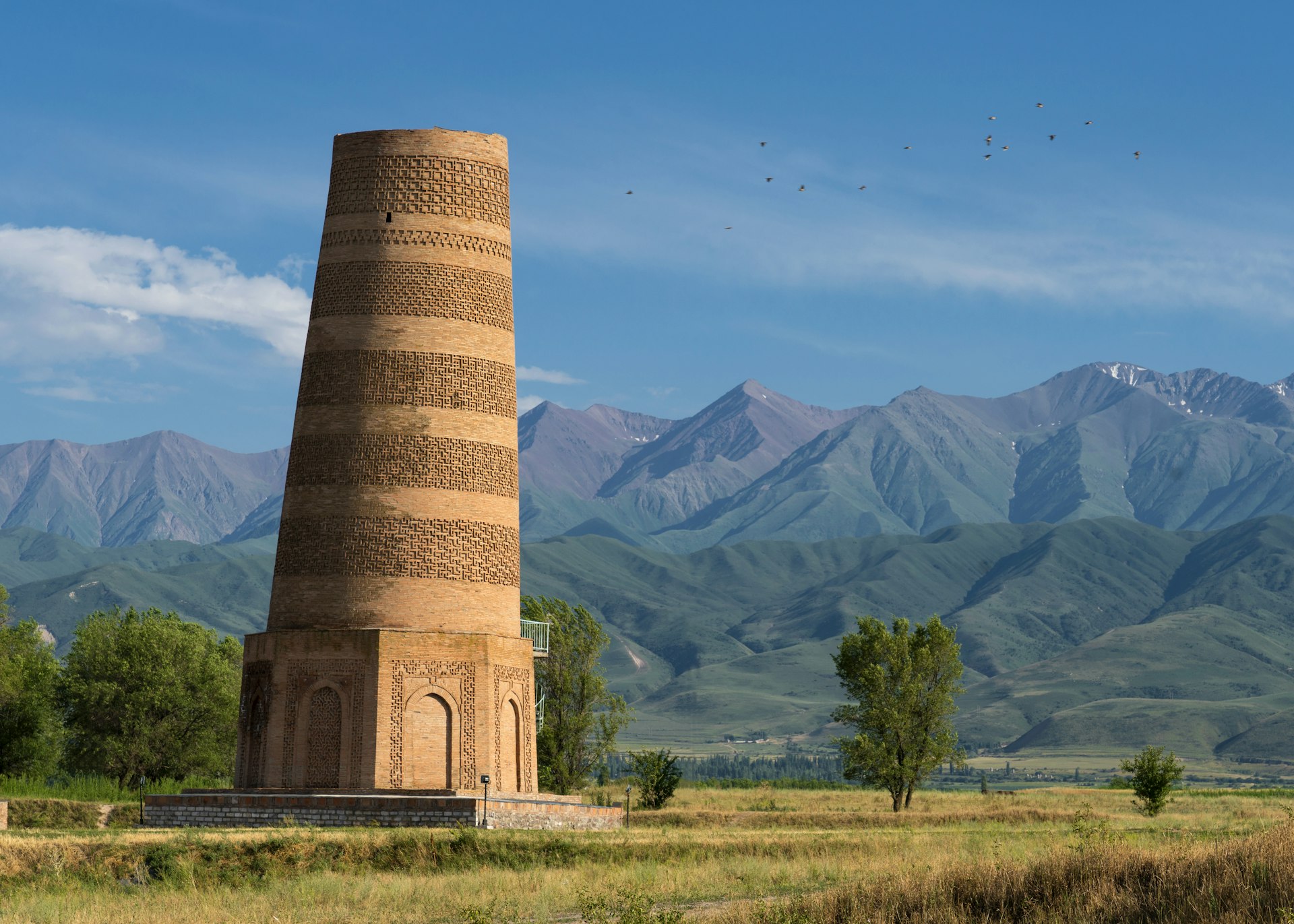 A stone tower backed by mountains