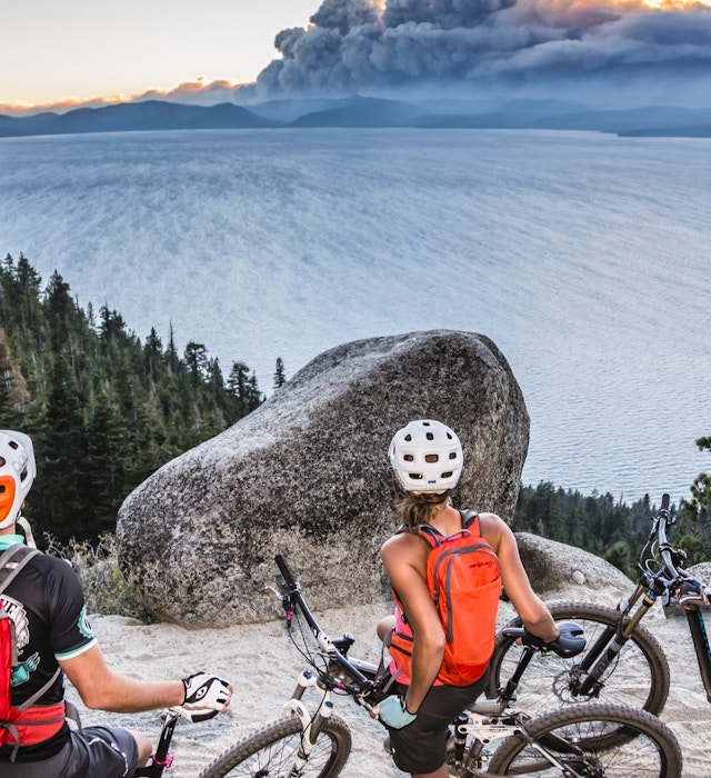 1270702234
Three mountain bikers take a rest on the Flume Trail, beside Lake Tahoe and watch the smoke clouds from the King Fire in the distance.
cloud, elevated view, king fire, mountain biker, non urban scene, purple color, red color, rock, smoke, sportswear, wildfire
