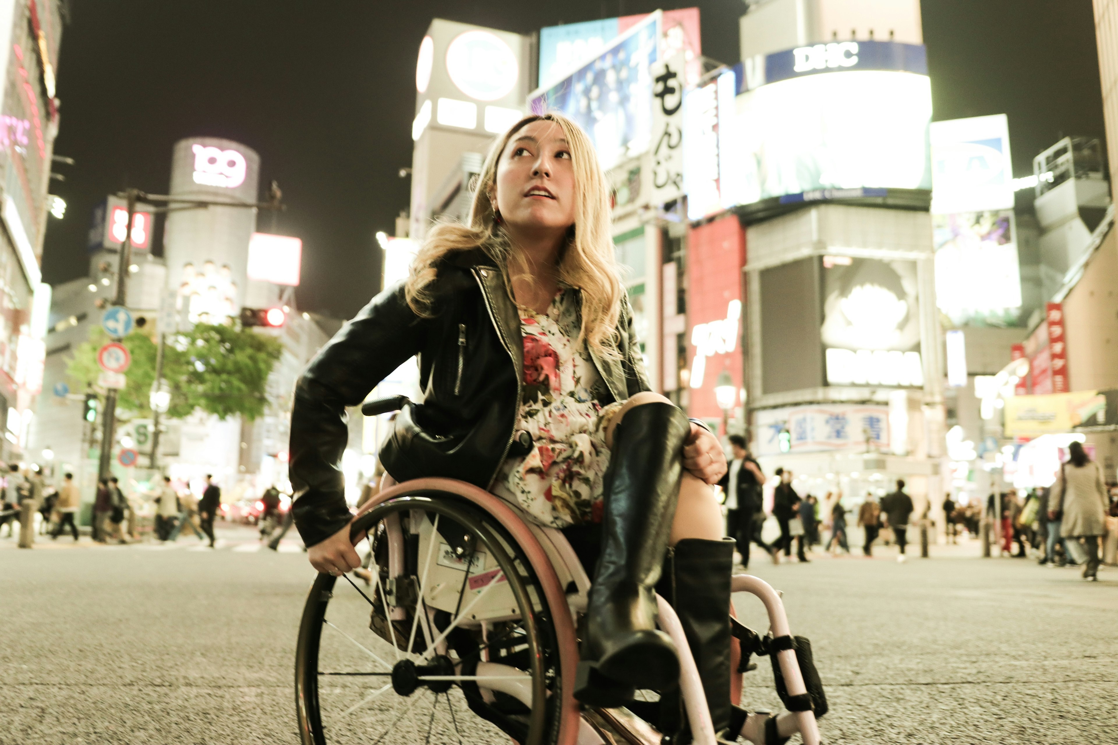 Cool Asian woman has a wheelchair enjoy the night life in Shibuya, Tokyo