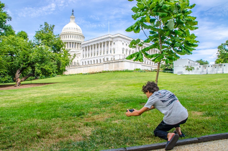 Teenage boy photographing Washington DC State Capitol during summer day
1421062108