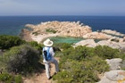 Woman admiring view over Cala Crucitta from hillside path, Caprera, Parco Nazionale dell'Arcipelago di La Maddalena, Sassari, Sardegna, Italy, Europe. Second largest of the islands in the Maddalena archipelago, Caprera lies to the north of the Gulf of Arzachena off the Galluran coast of Sardinia, Punta Crucitta being its northernmost point. Scarcely populated, the island was home to Giuseppe Garibaldi, father of Italian unification, for almost thirty years, while its unspoilt natural environment has made it a popular hiking destination. The Maddalena Archipelago National Park was established in 1994, the first such park to be created in Sardinia.
1467837197