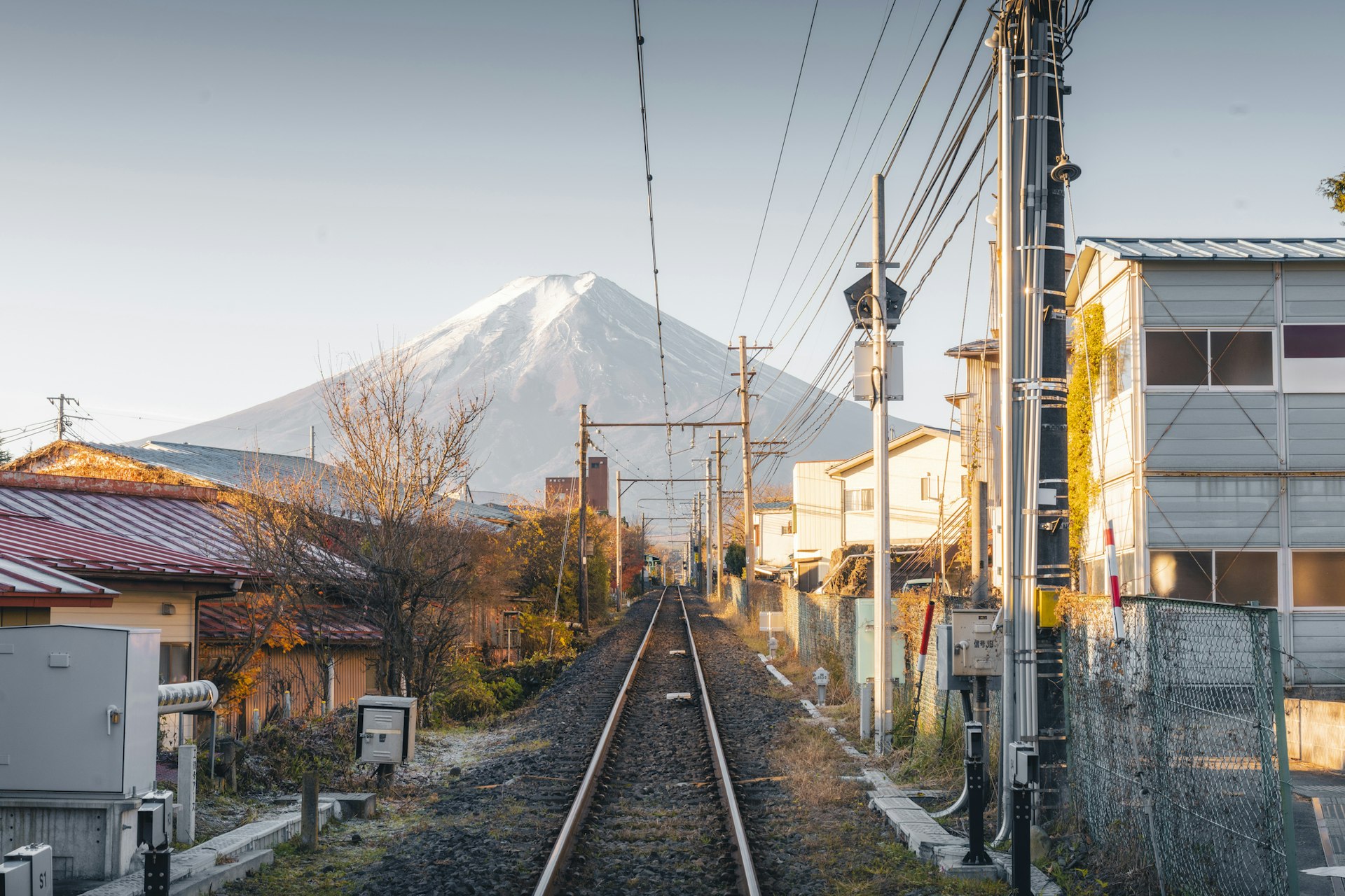 A single-track train line heading towards the iconic shape of Mount Fuji