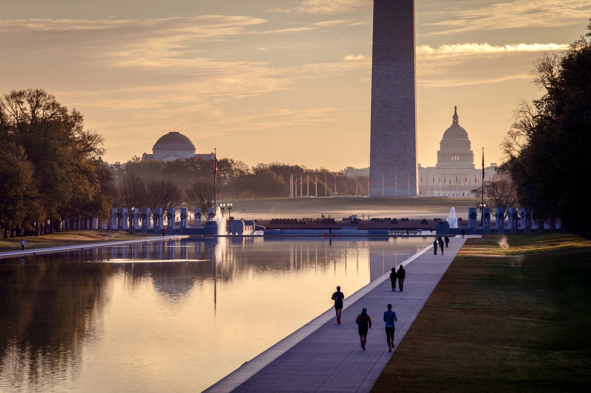 Vibrant sunrise over the National Mall in Washington DC, with people walking and running in the foreground