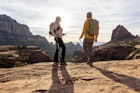 Mature couple pause on red rock path in desert landscape
1875654186