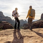 Mature couple pause on red rock path in desert landscape
1875654186