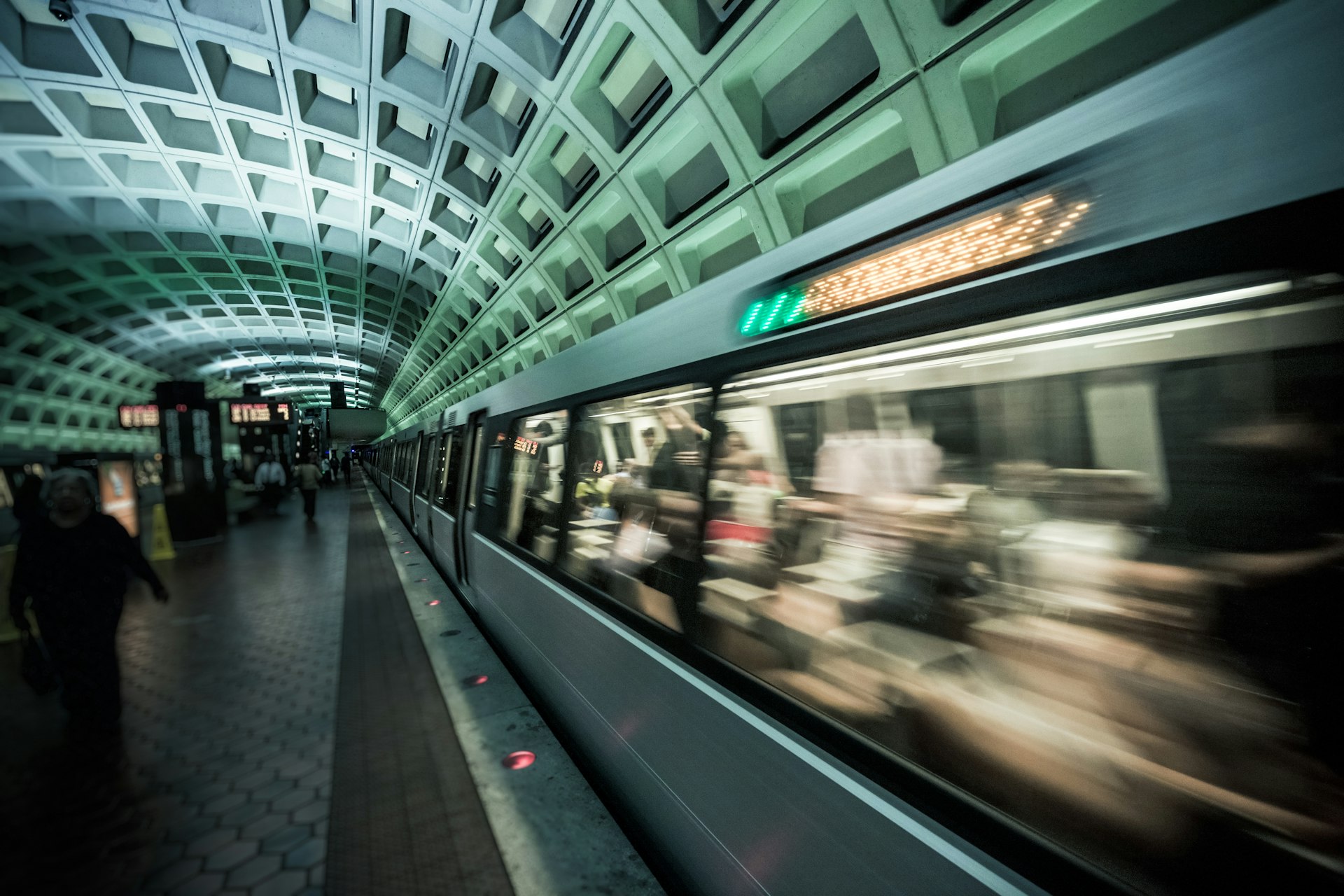 A subway train passes commuters at the Dupont Station in Washington, DC