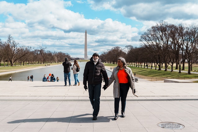USA-Washington-DC-Fly View Productions-GettyImages-2052274111-RF Black senior couple exploring the Washington Mall while visiting Washington DC. A vibrant senior couple walk hand in hand while touring Washington DC on a fun and relaxing winter vacation, with the Lincoln Memorial Reflecting Pool and Washington Monument visible in the background. © Fly View Productions / Getty Images