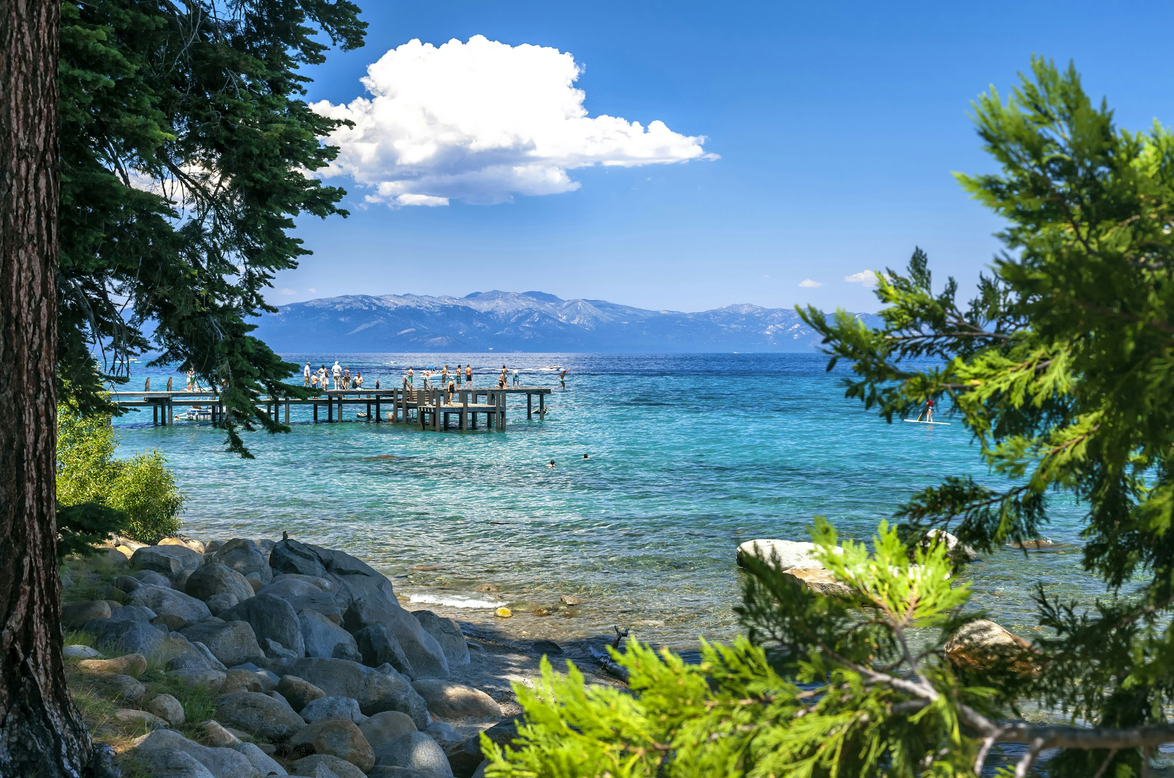 Kids playing on a jetty and diving into a lake