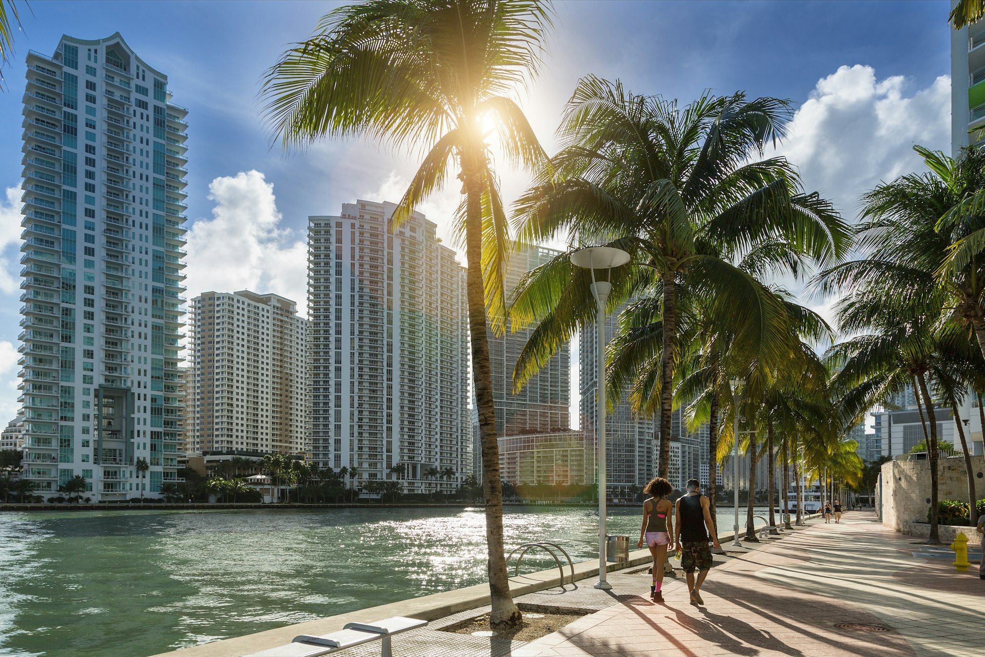 People walking by the waterfront with towers in the distance, Downtown Miami, Florida, USA