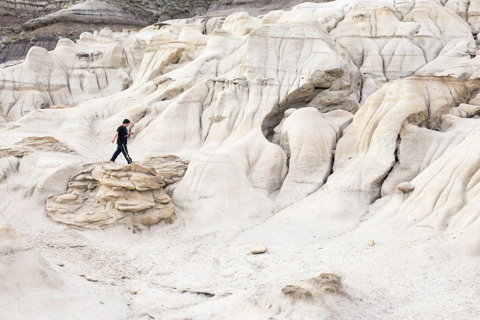 A teenager hikes across a white rocky landscape