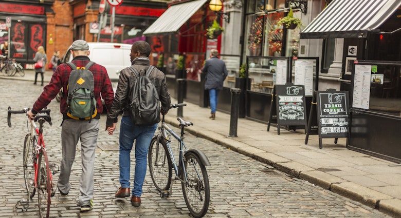Mixed race gay men with bicycles in the city in the Temple Bar district of Dublin, Ireland