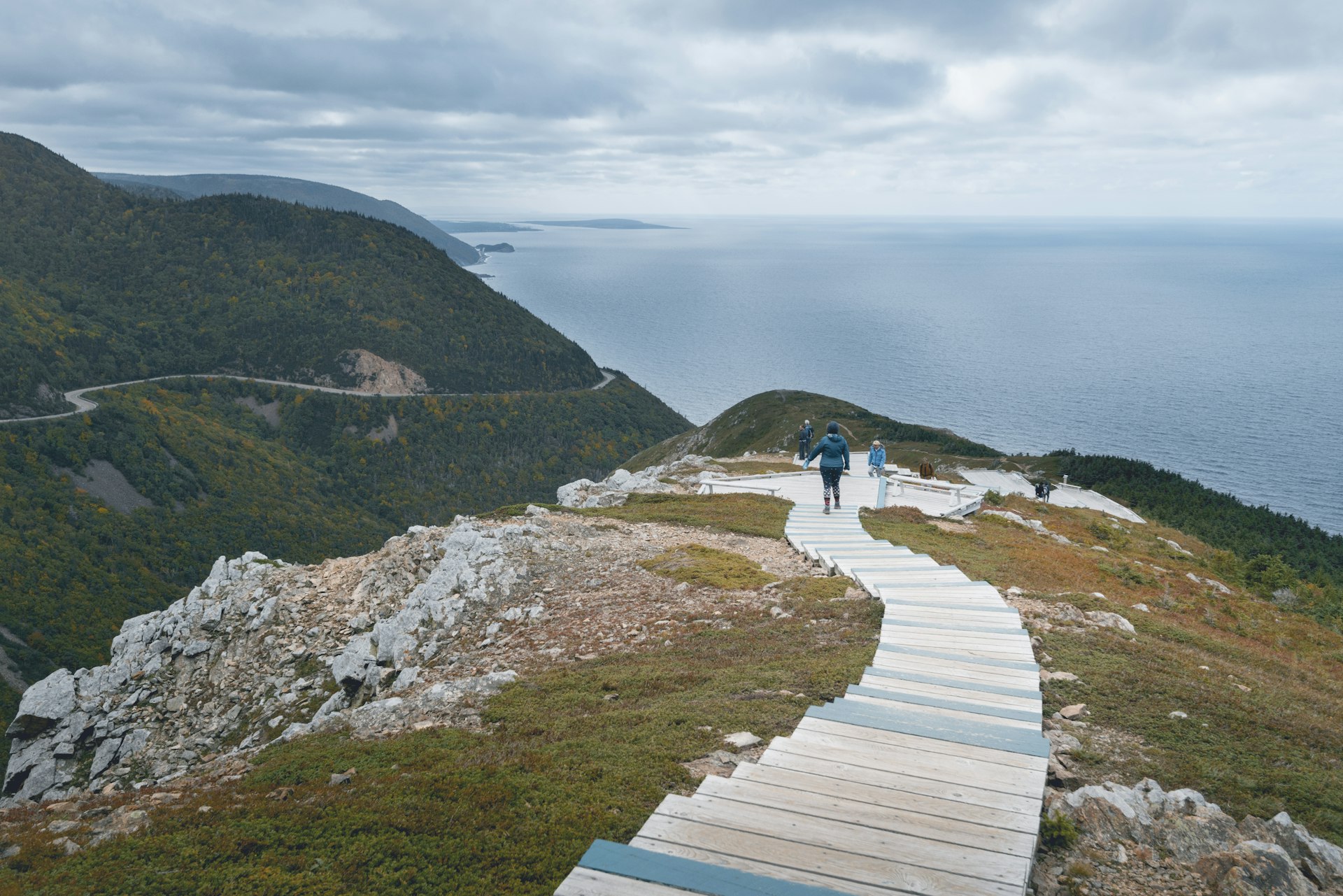 Pessoas caminham pela Skyline Trail acima do oceano no Parque Nacional Cape Breton Highlands, Nova Escócia, Canadá