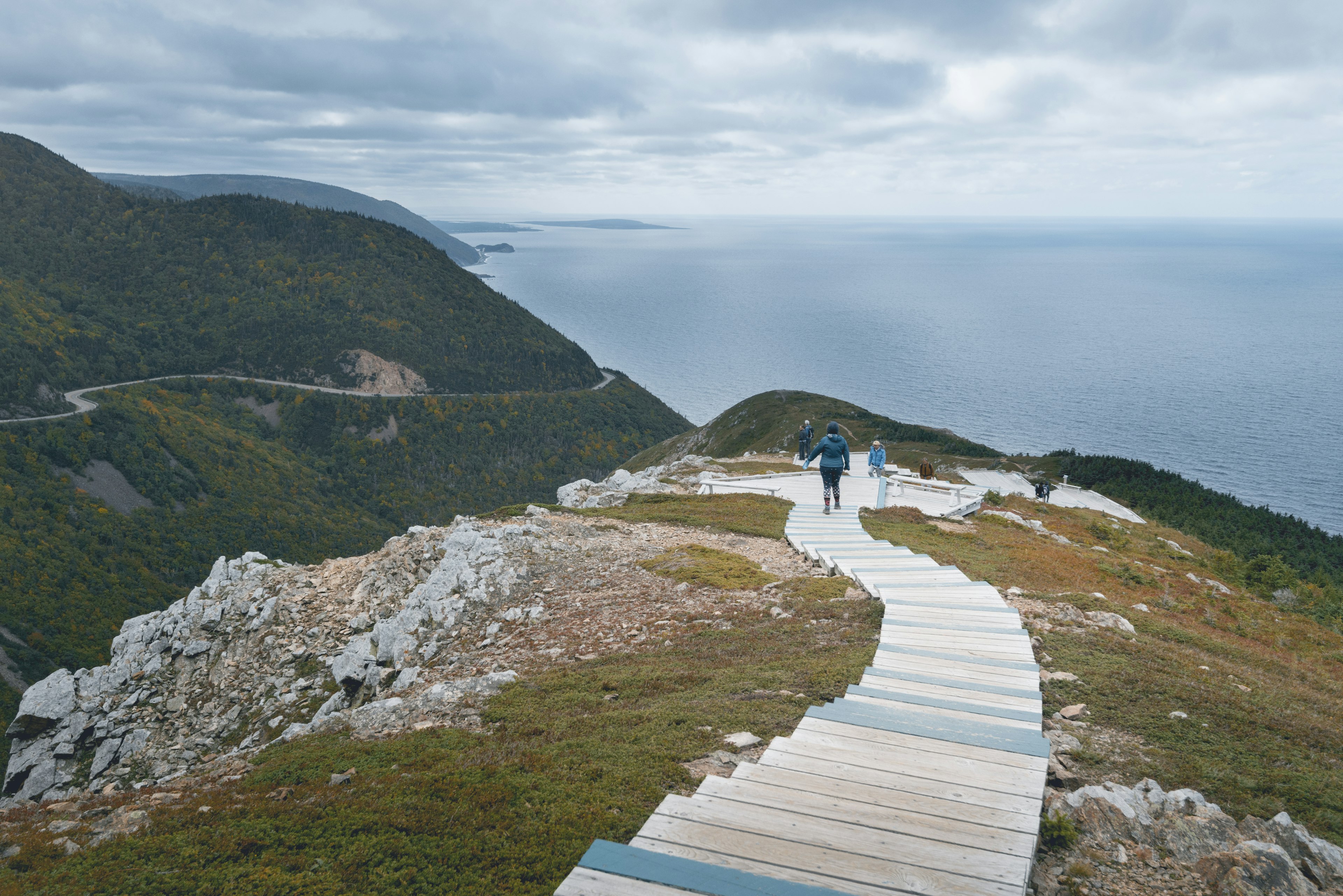 People walk the Skyline Trail above the ocean in Cape Breton Highlands National Park, Nova Scotia, Canada