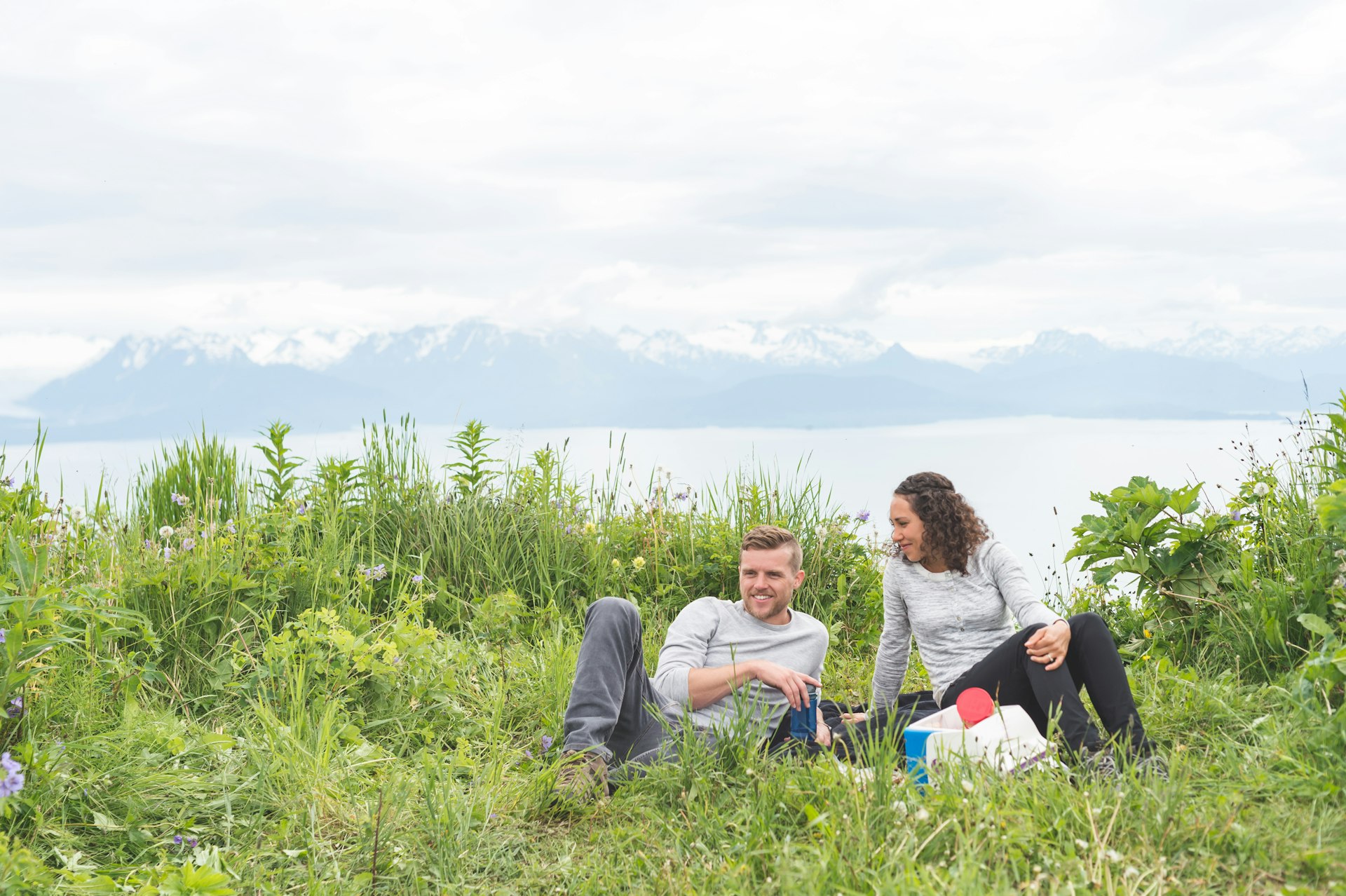 A couple enjoys a picnic with mountains in the distance, Alaska, USA