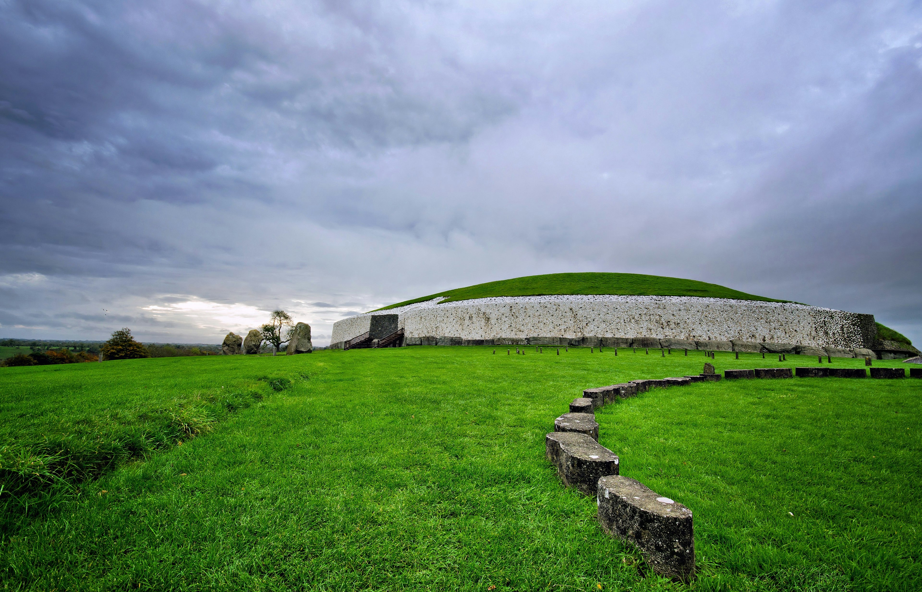 The vast bulge of burial mound set in grassy countryside