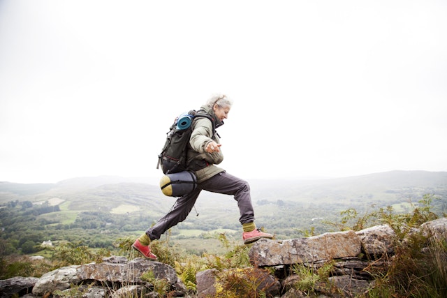 Older woman happily trekking in the mountains around Kenmare.