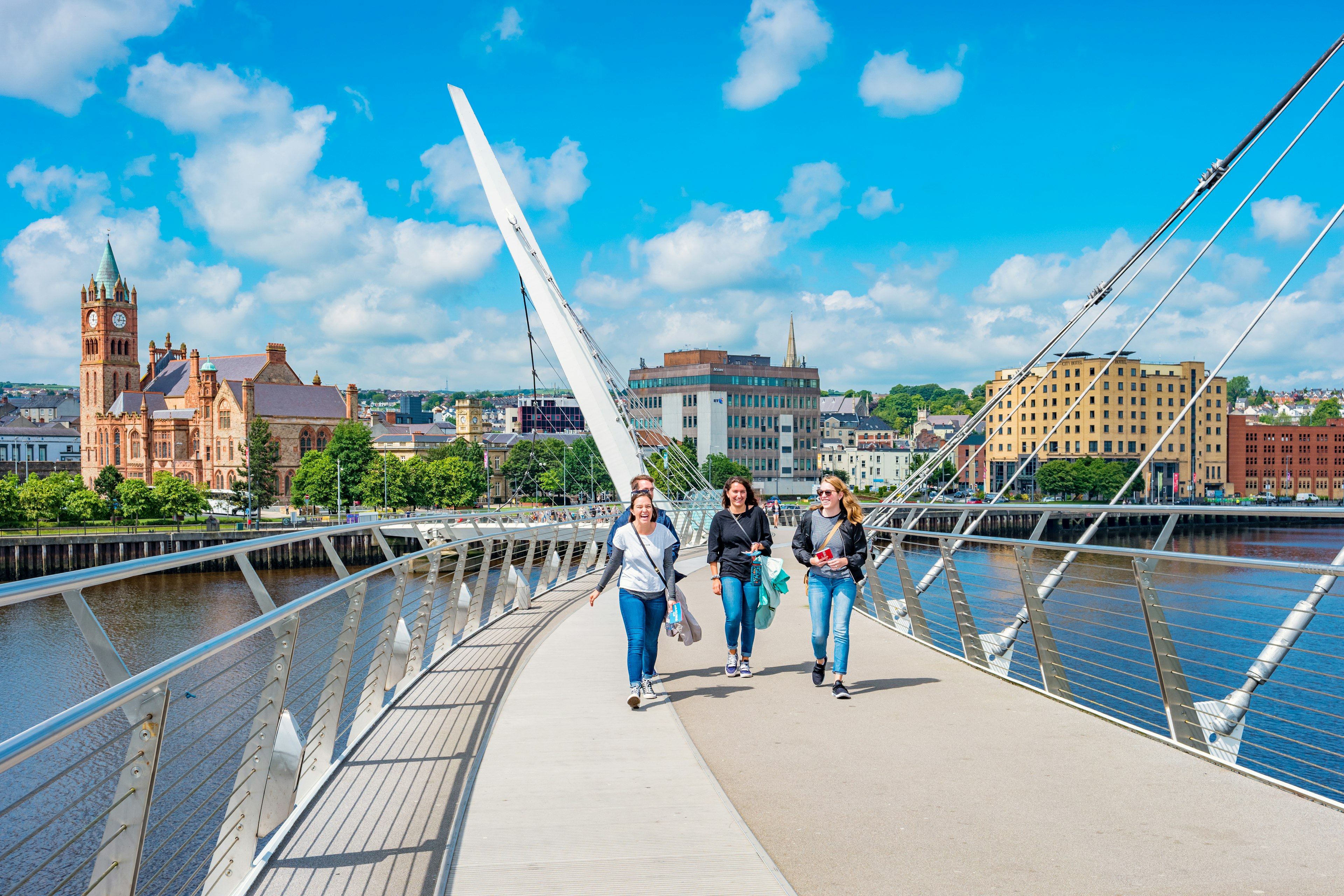 Young women cross the Peace Bridge in Derry, Northern Ireland