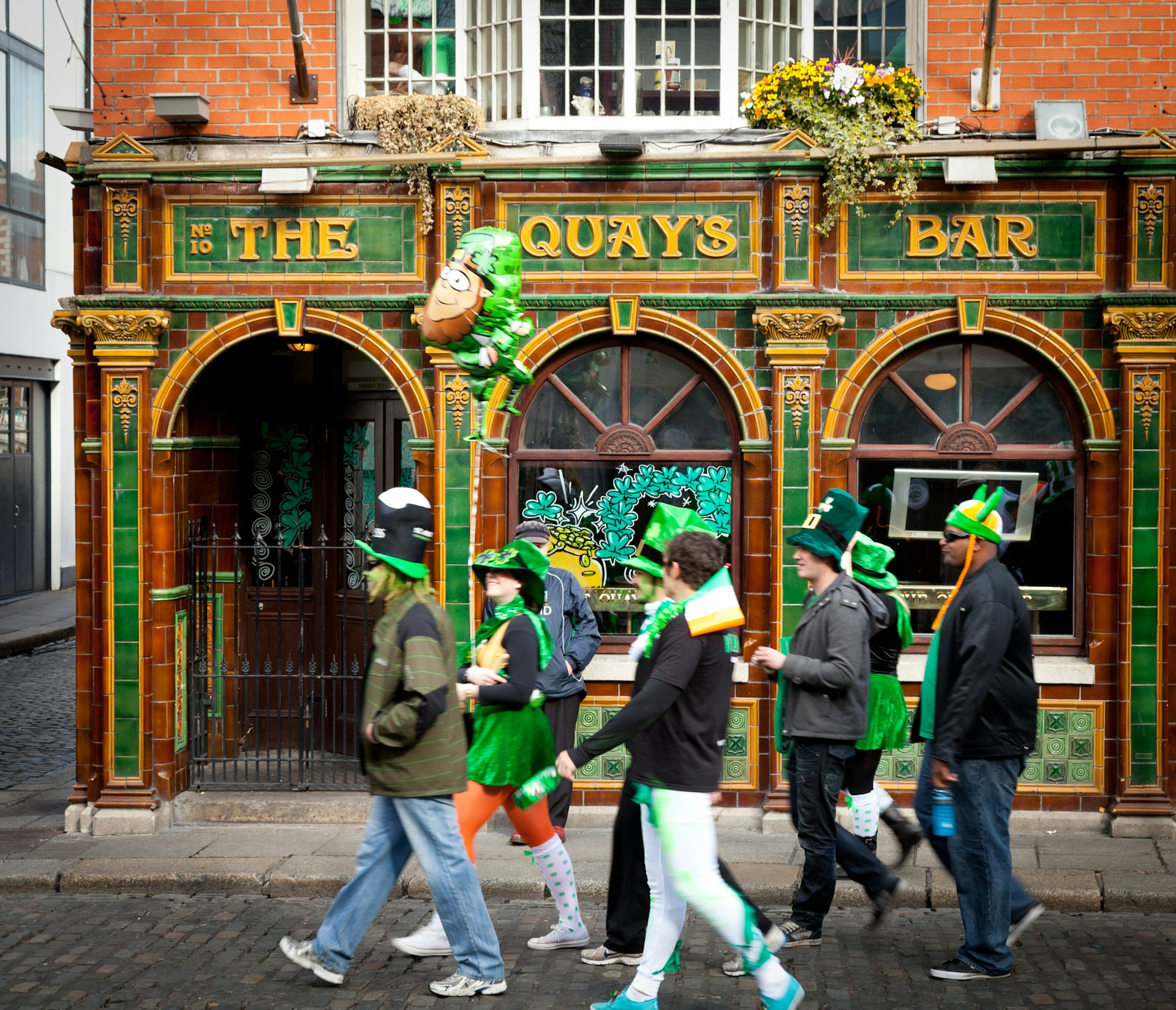 Group of people in costumes Ireland in the Republic of Ireland passing a Dublin pub on St. Patrick's Day
