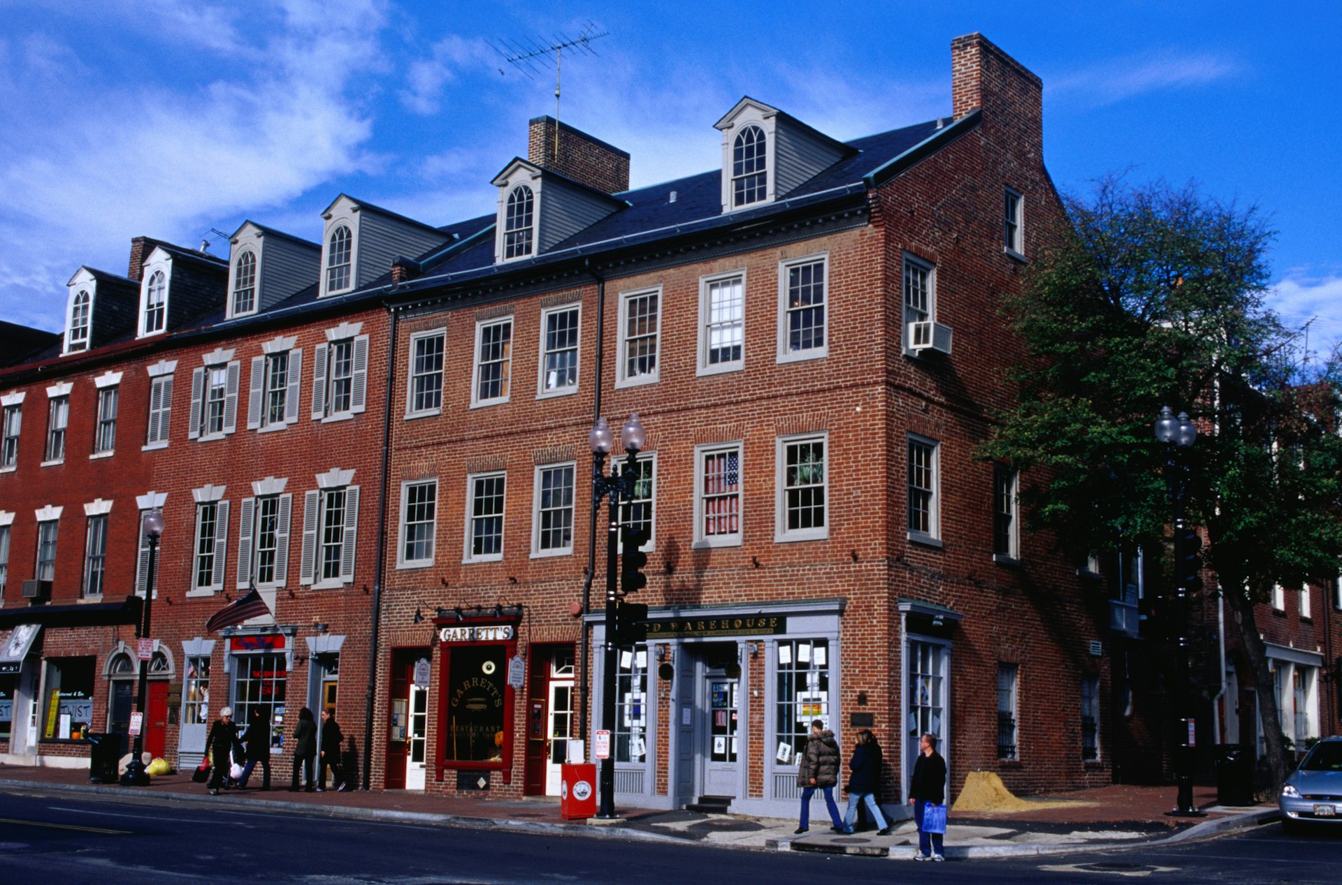 People walk by historic brick buildings in Georgetown, Washington, DC, USA