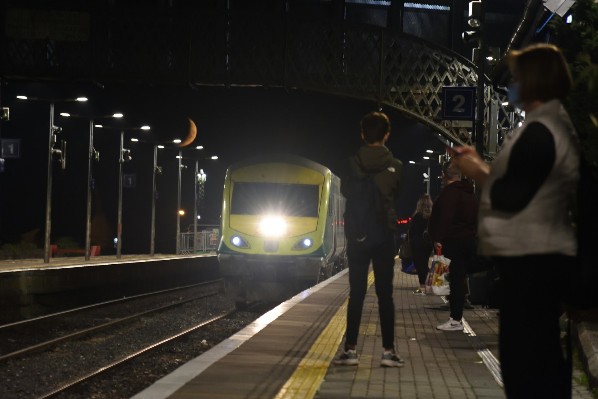 A busy train platform in the evening
