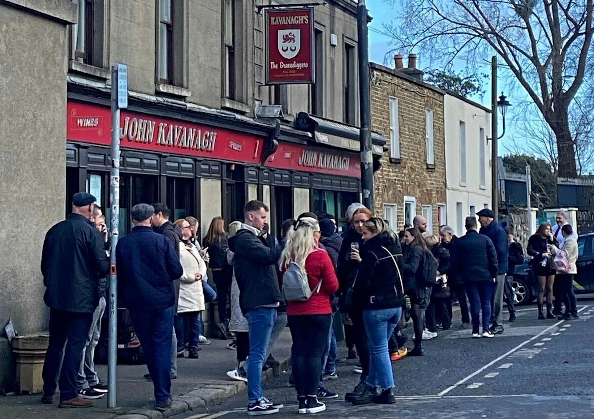 People gather in front of John Kavanagh's aka Gravediggers pub, in Dublin on a winter day