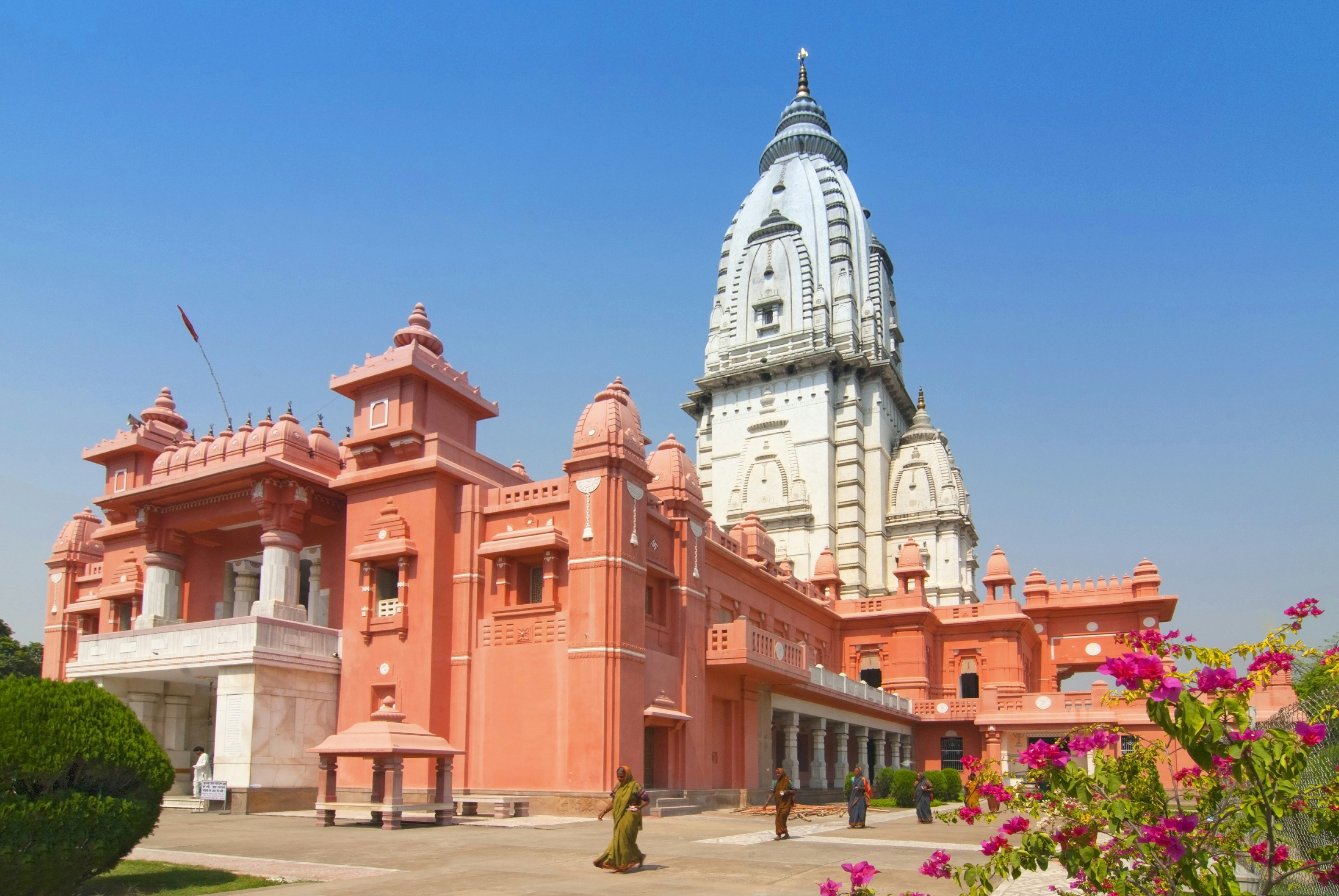 A red-orange walled temple with a white tower on top