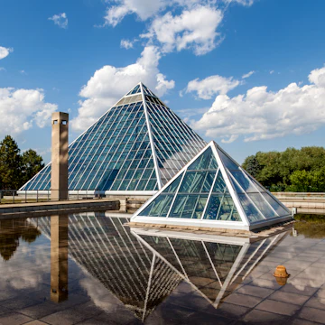 Edmonton, Canada - July 8, 2014: A Summer view of the Muttart Conservatory, one of Edmonton's most famous icons built in 1976 by architect Peter Hemingway. The conservatory features unique greenhouses and gardens that display plant species found across three biomes,
506715369
Alberta, Architecture, Beauty, Botany, Building Exterior, Built Structure, Canada, City Life, Contemporary, Creativity, Ecosystem, Edmonton, Fame, Famous Place, Formal Garden, Glass, Greenhouse, Inspiration, International Landmark, Multi Colored, Muttart, Muttart Conservatory, Nature, Ornamental Garden, Outdoors, Plant, Pyramid, Pyramid Shape, Scenics, Sky, Tranquil Scene, Urban Scene, Vitality, Window, botanic, glass building