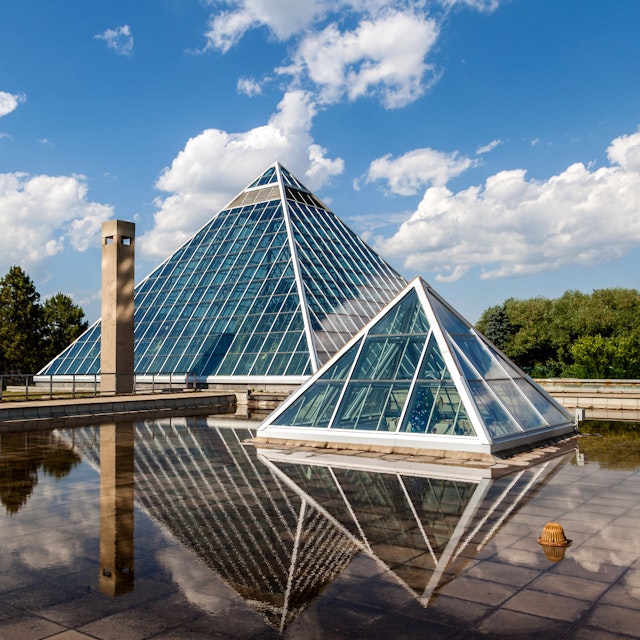 Edmonton, Canada - July 8, 2014: A Summer view of the Muttart Conservatory, one of Edmonton's most famous icons built in 1976 by architect Peter Hemingway. The conservatory features unique greenhouses and gardens that display plant species found across three biomes,
506715369
Alberta, Architecture, Beauty, Botany, Building Exterior, Built Structure, Canada, City Life, Contemporary, Creativity, Ecosystem, Edmonton, Fame, Famous Place, Formal Garden, Glass, Greenhouse, Inspiration, International Landmark, Multi Colored, Muttart, Muttart Conservatory, Nature, Ornamental Garden, Outdoors, Plant, Pyramid, Pyramid Shape, Scenics, Sky, Tranquil Scene, Urban Scene, Vitality, Window, botanic, glass building