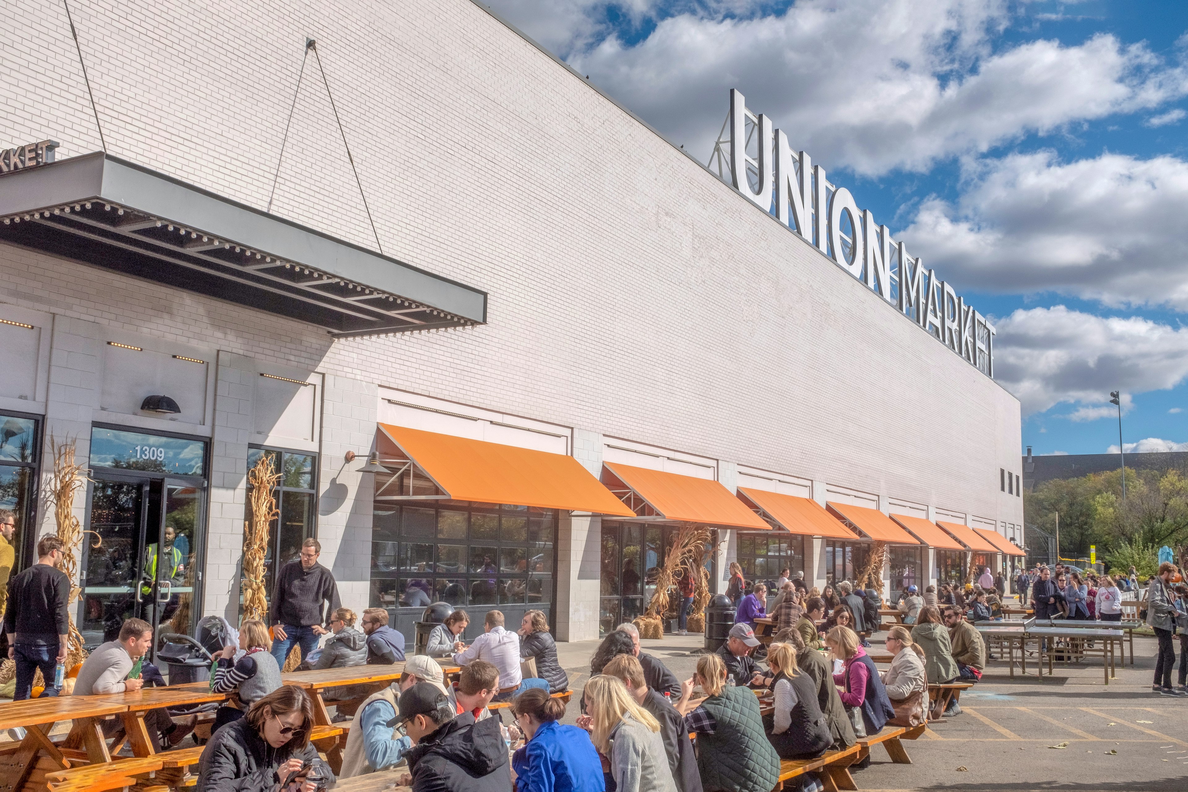 Customers eat at outdoor picnic tables at Union Market, NoMa, Washington, DC, USA