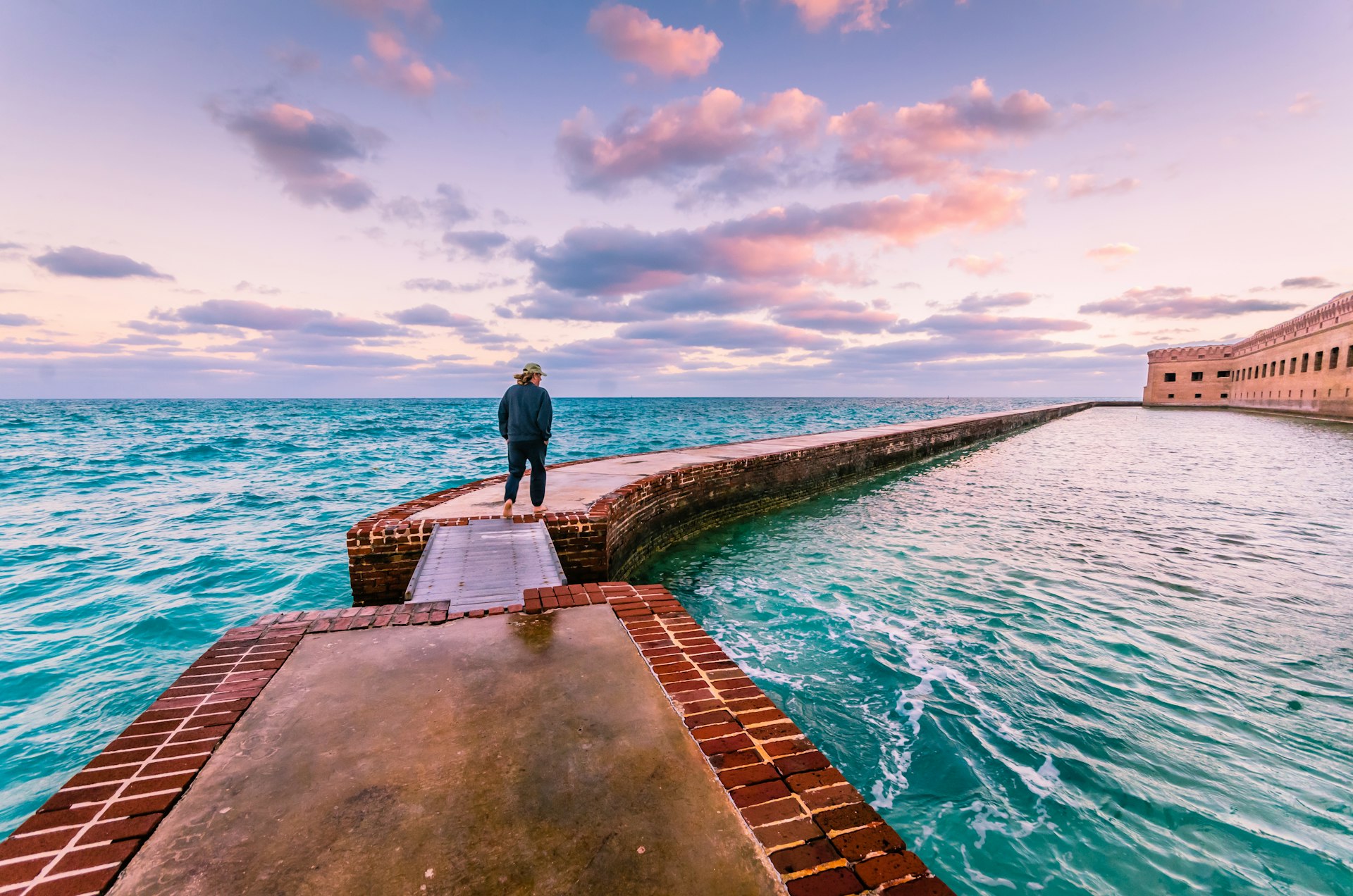 Man takes a morning walk on the moat around Port Jefferson at Dry Tortugas National Park, Florida Keys, Florida, USA