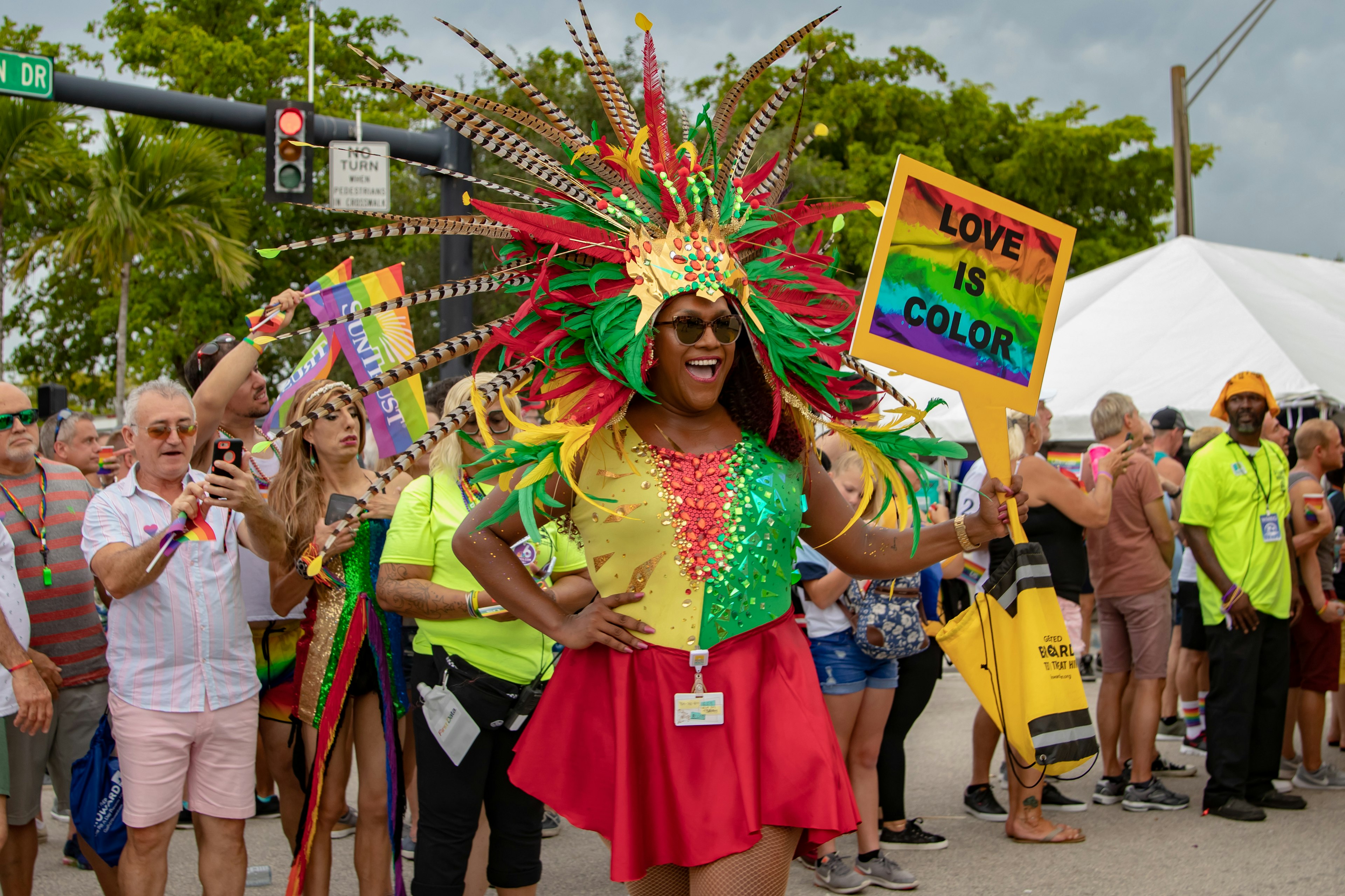 A woman in a bright, feathered costume at the Stonewall Pride Parade in Florida