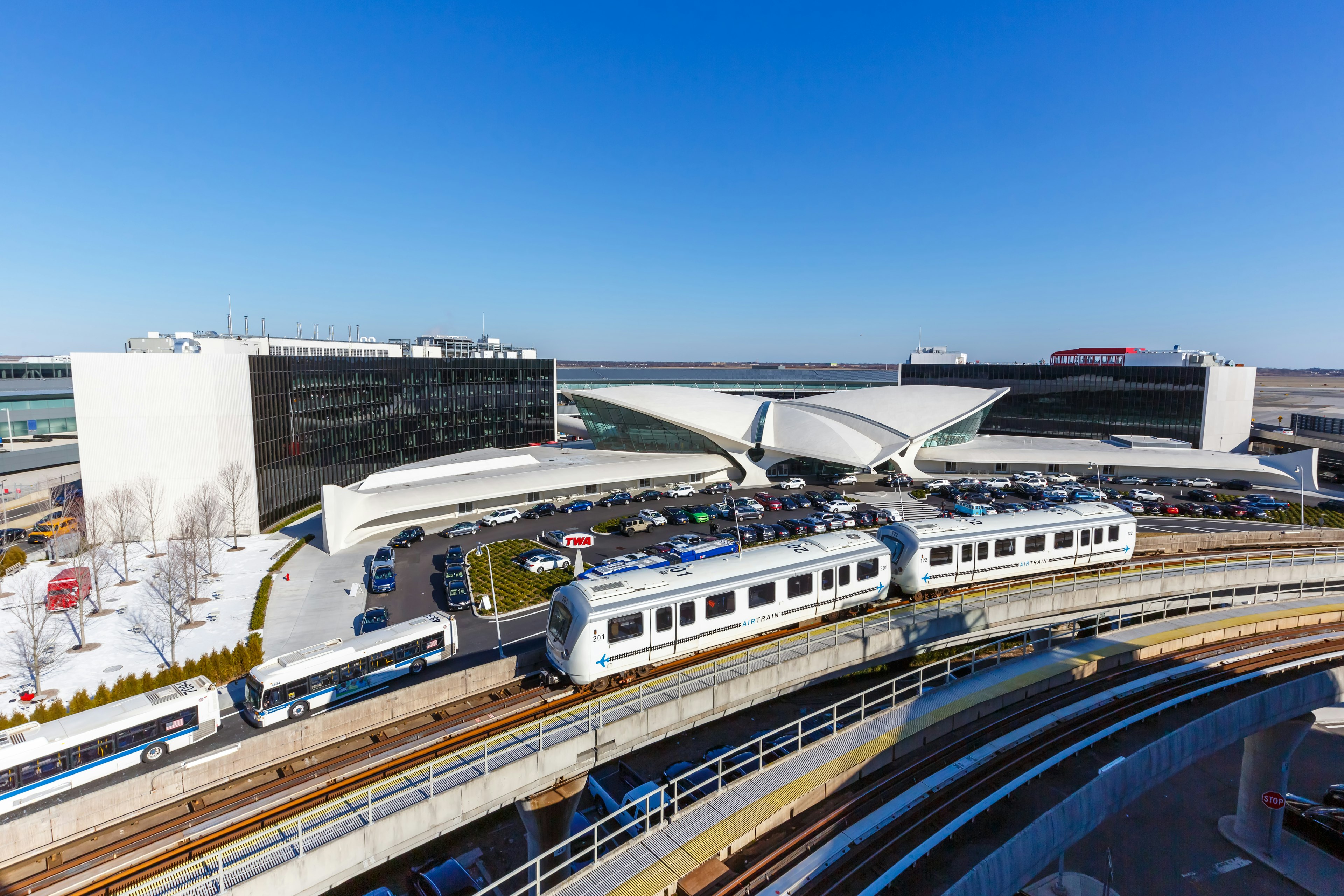 An AirTrain passes the TWA Hotel at John F Kennedy International Airport, Queens, New York City, New York, USA