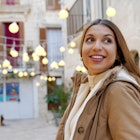 Christmas vibes. Close-up of winter woman walking between alleys decorated with lights in historic town on evening.; Shutterstock ID 2222544341; GL: 65050; netsuite: Online Editorial; full: When to go Puglia; name: Bailey Freeman
2222544341
