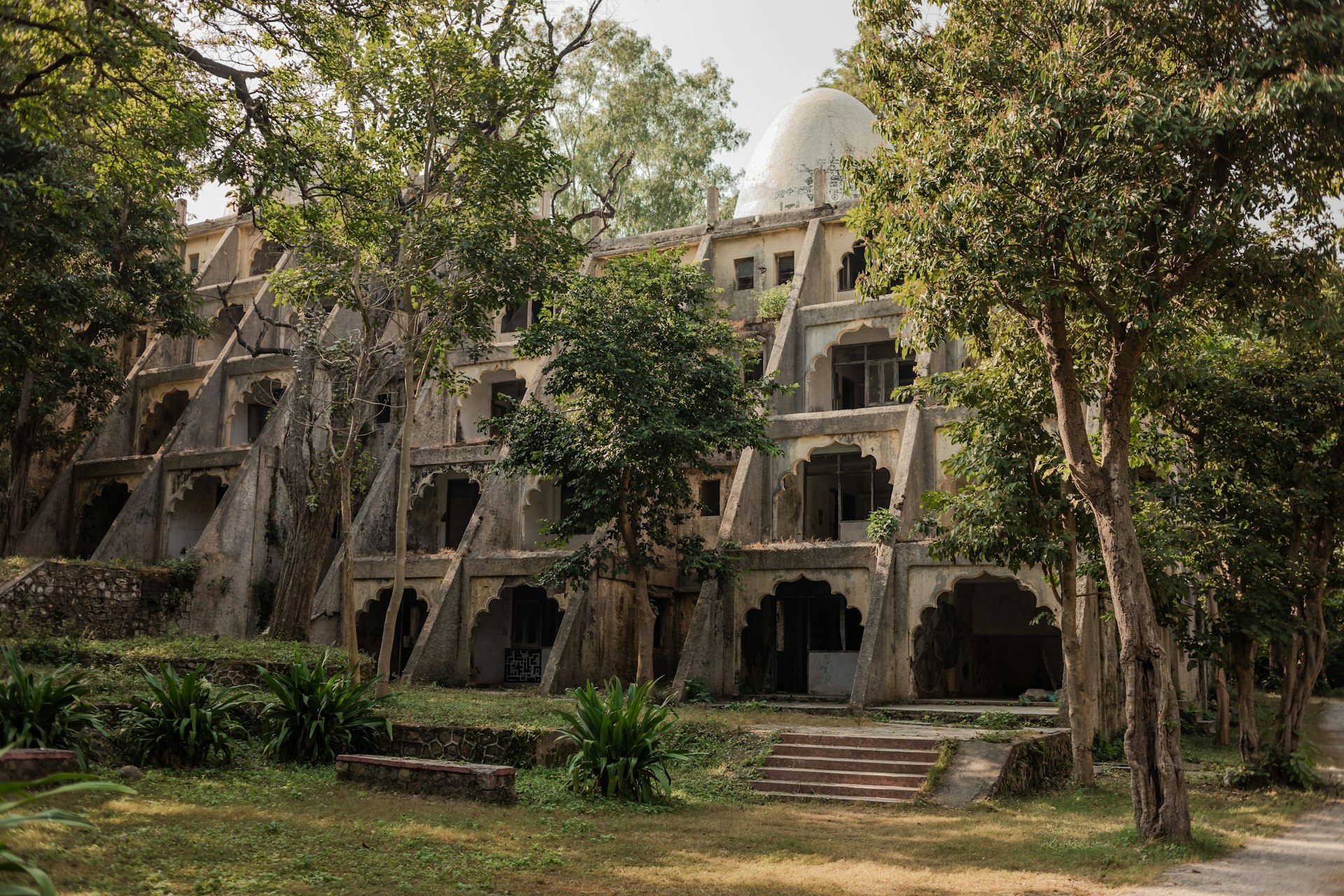 An ashram building surrounded by thick trees