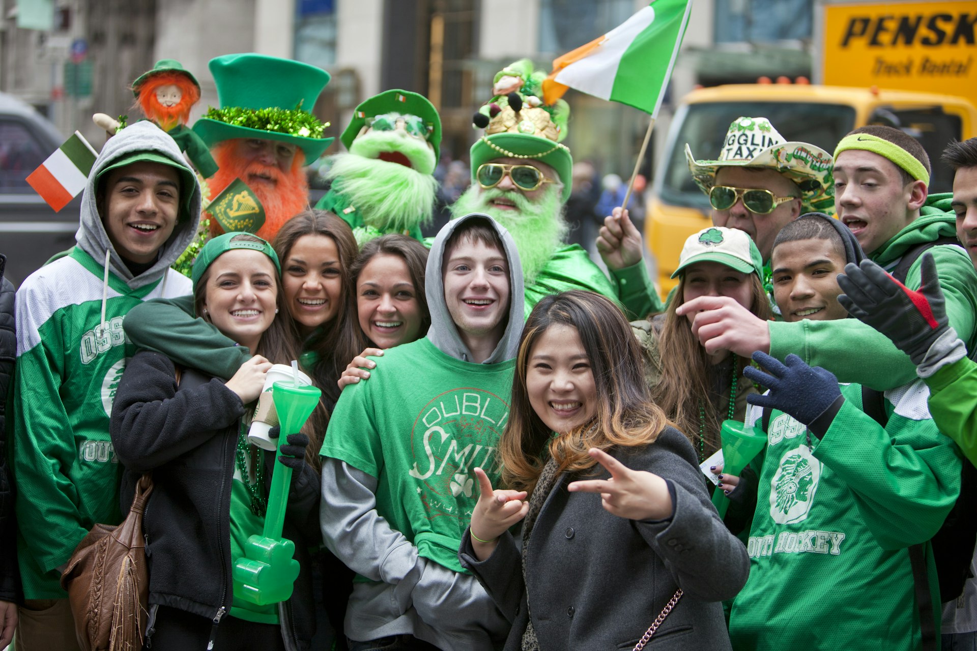 A crowd of people wearing green smile for the camera