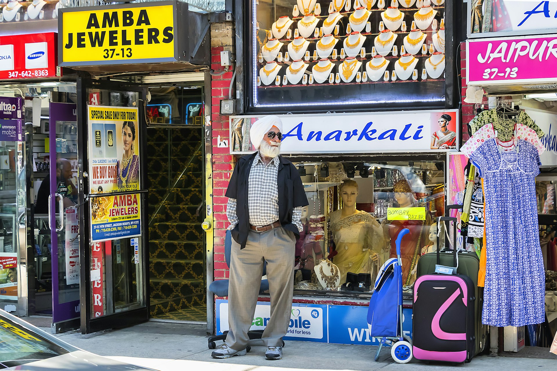 A man of Indian descent wearing a turban in front of stores in Jackson Heights, Queens, New York City, New York, USA