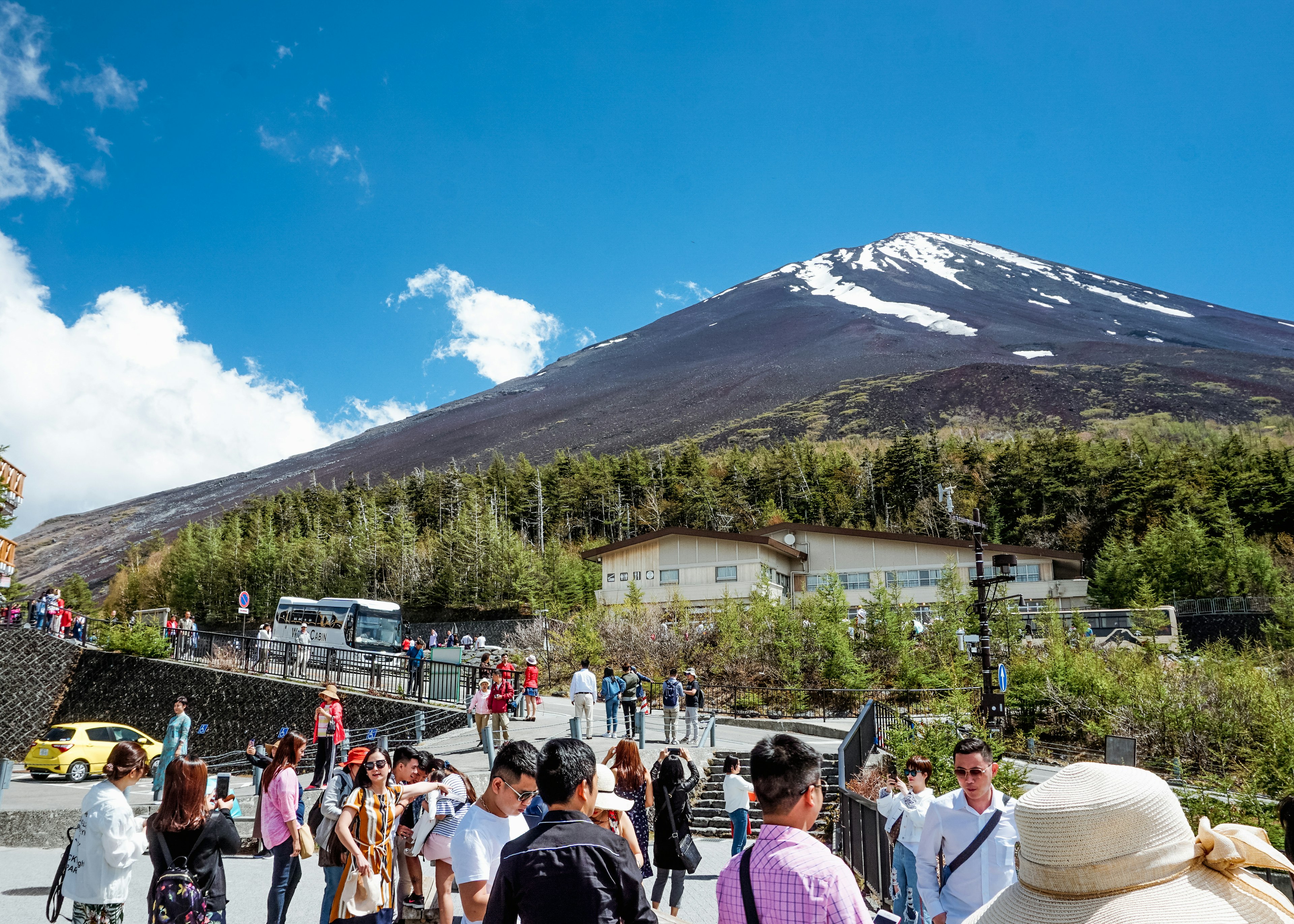 Visitors at Fuji Subaru Line 5th Station with Mount Fuji beyond.