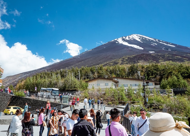 Visitors at Fuji Subaru Line 5th Station with Mount Fuji beyond.
