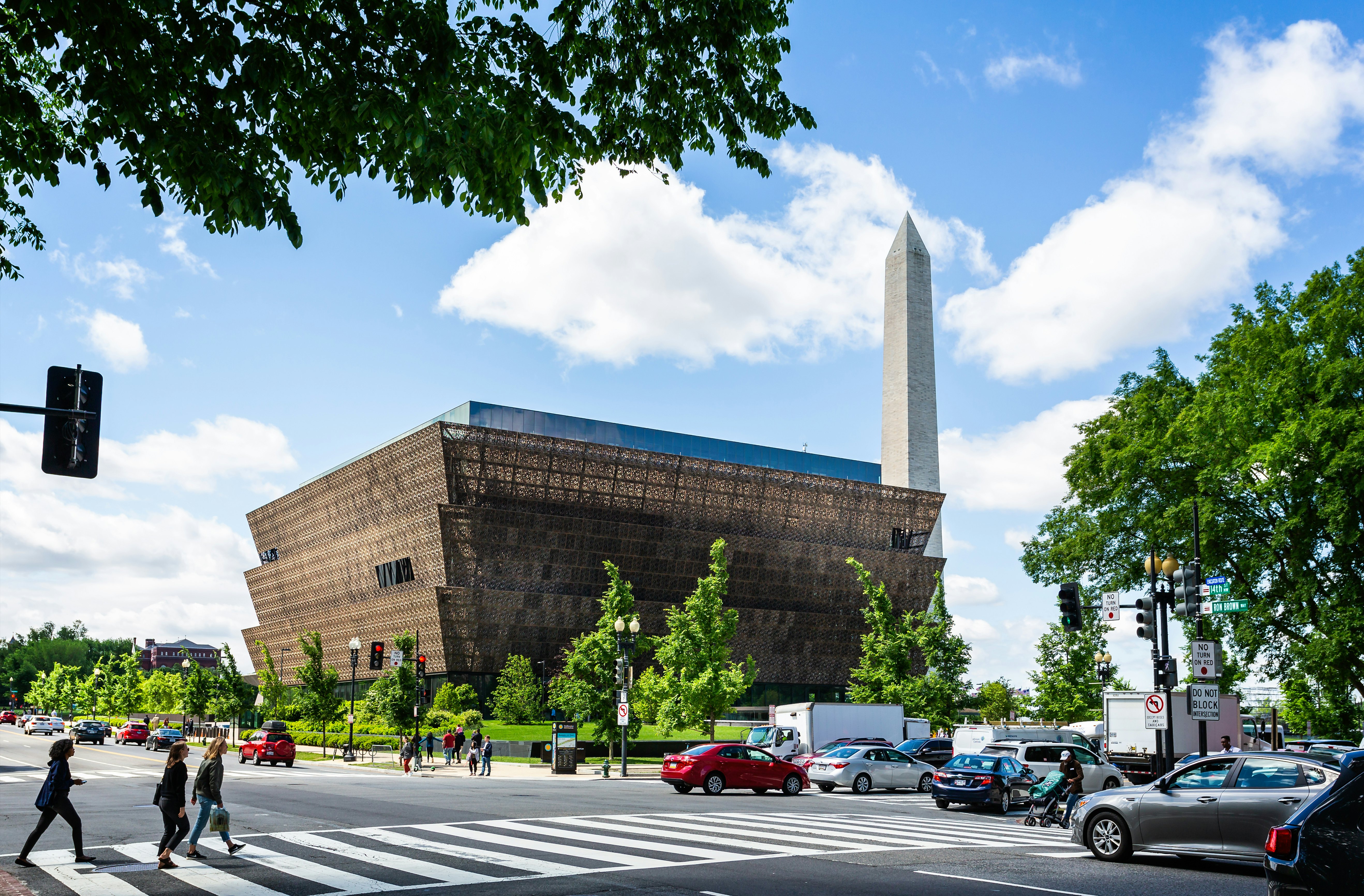 Cars parked at the side of the road near a large museum building