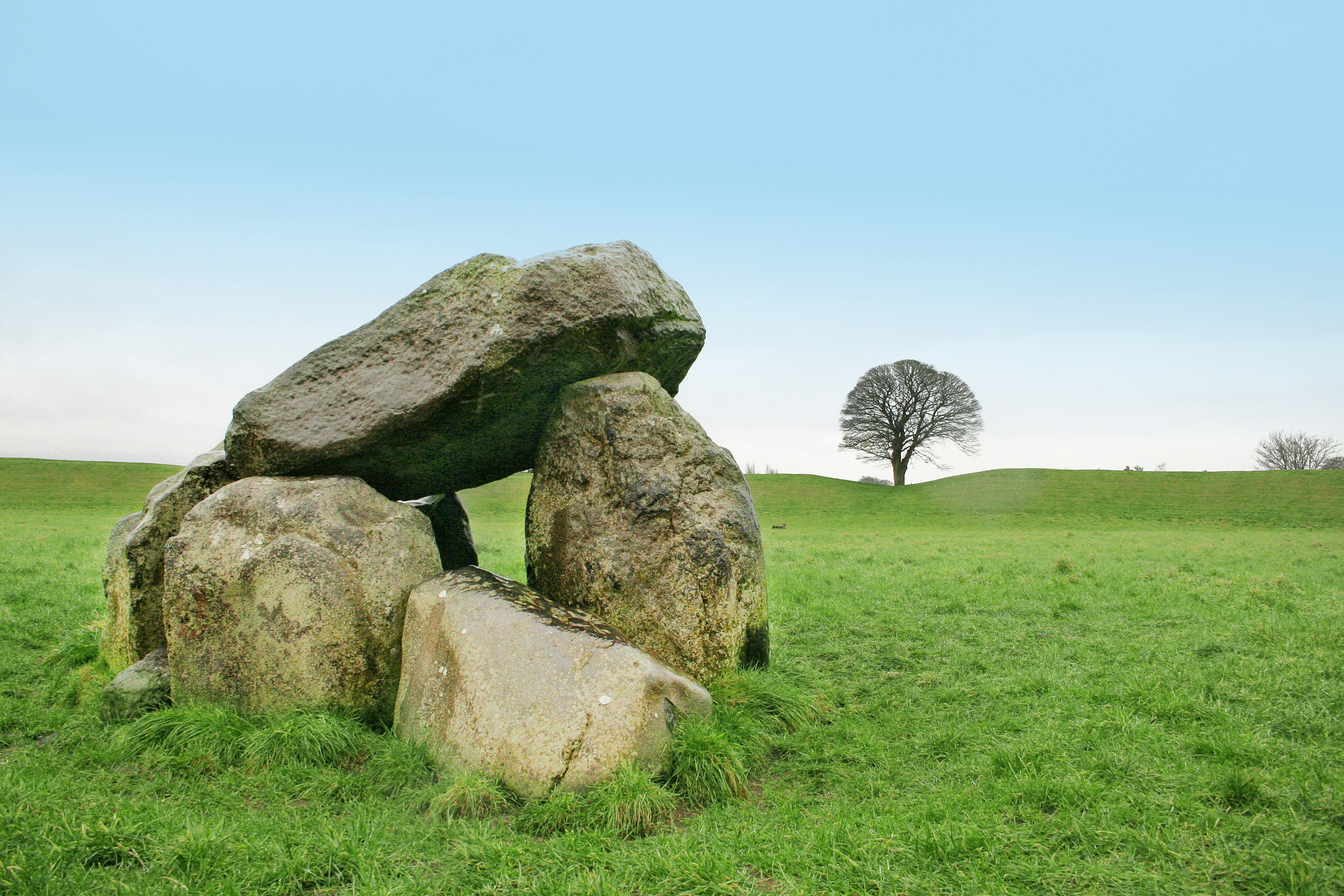 Carrowmore an Old celtic megalith in a green field with blue sky