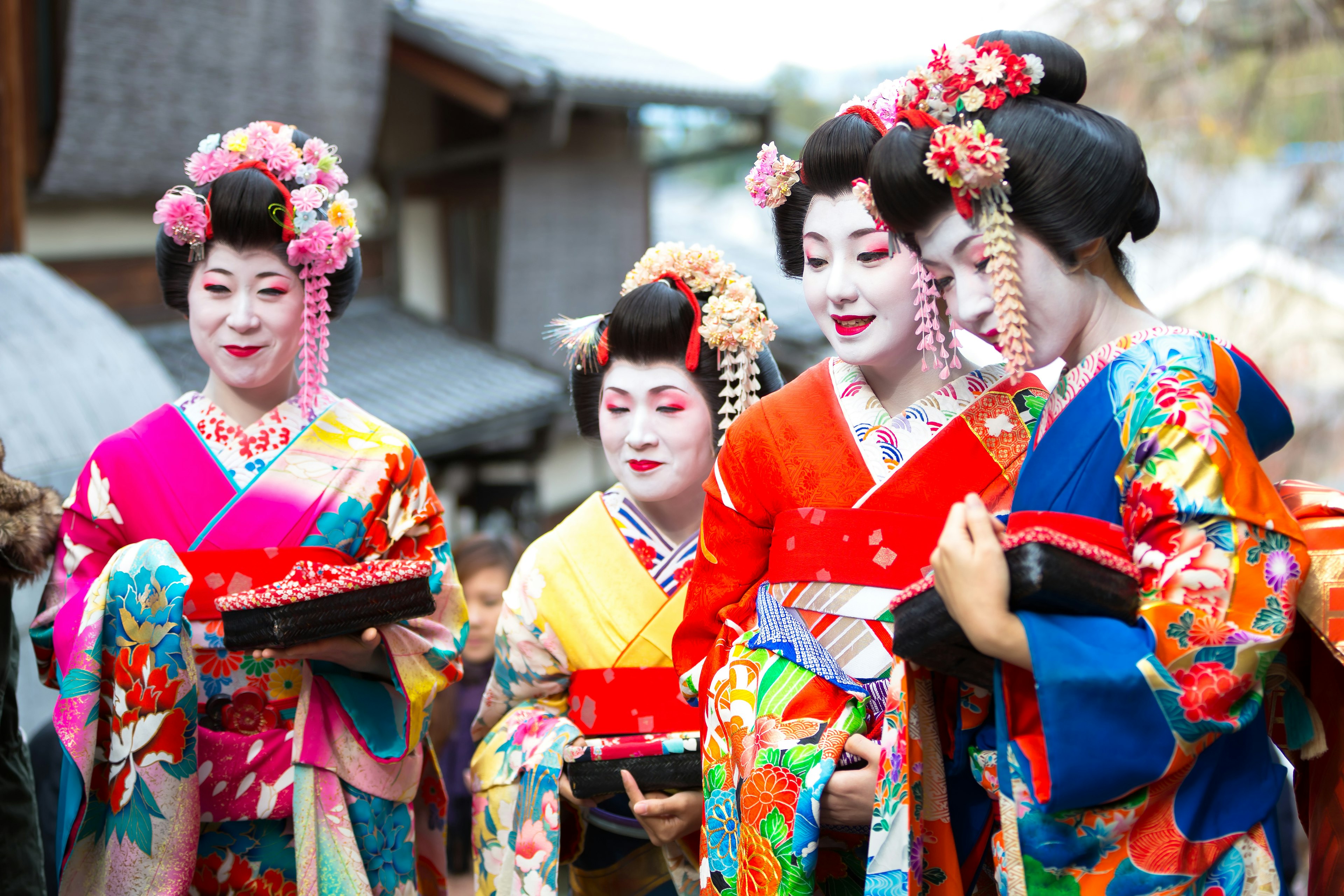 A group of four women with white-painted faces and colorful kimono