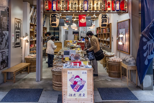 Shoppers browse and buy local products in one of the typical small shops located in the outer area of the Tsukiji Market, in Tokyo, Japan
