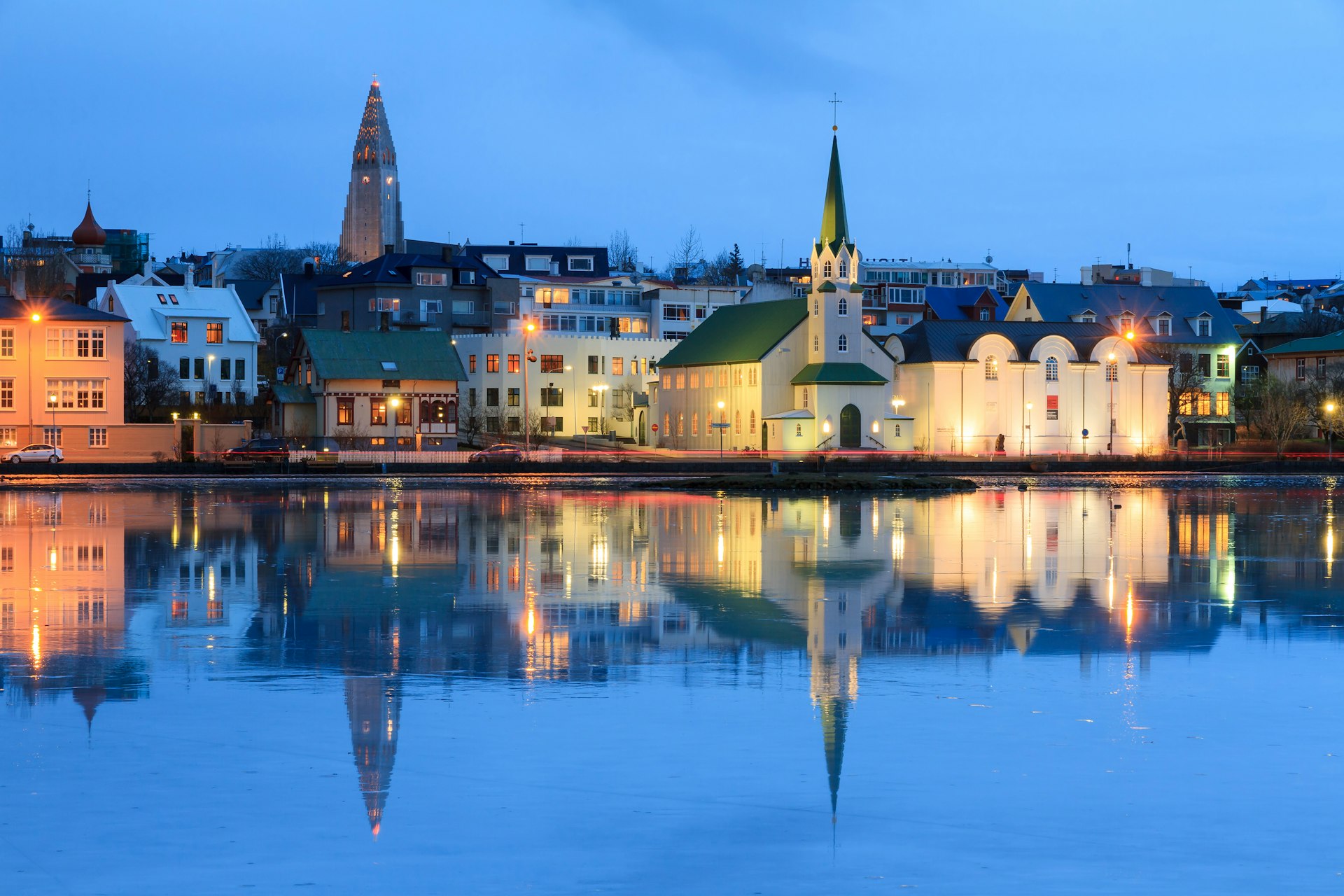Reflection of the cityscape in Lake Tjornin during a winter twilight, Reykjavík, Iceland