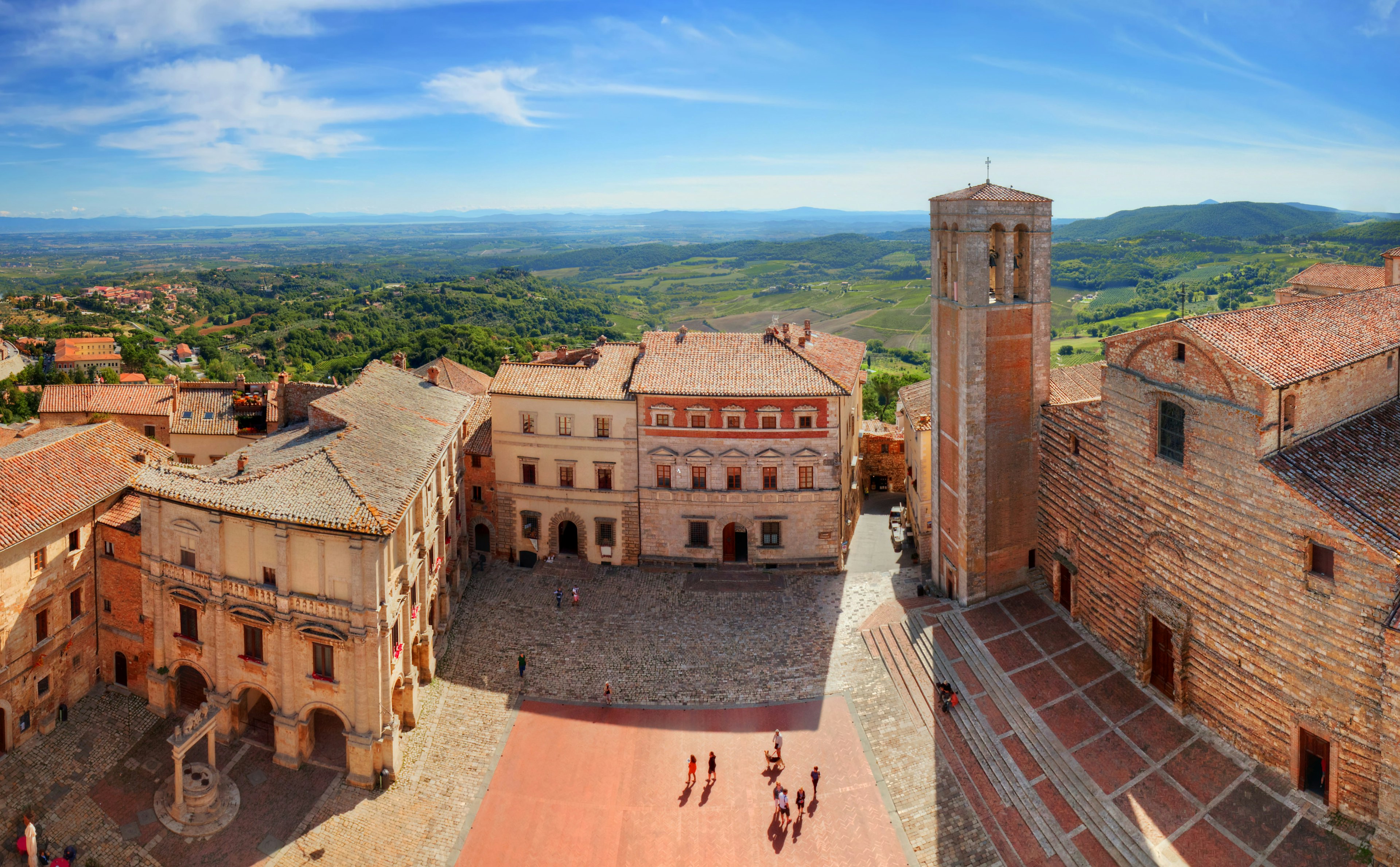 A high-angle shot down towards a square with groups of tourists milling around