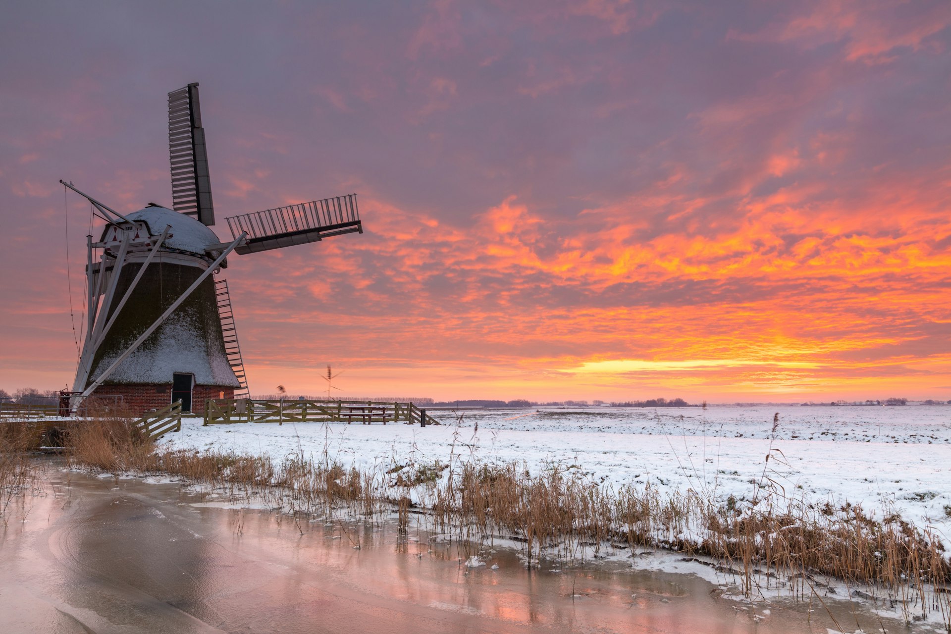 Meervogel windmill at sunset in winter with ice and snow in the foreground