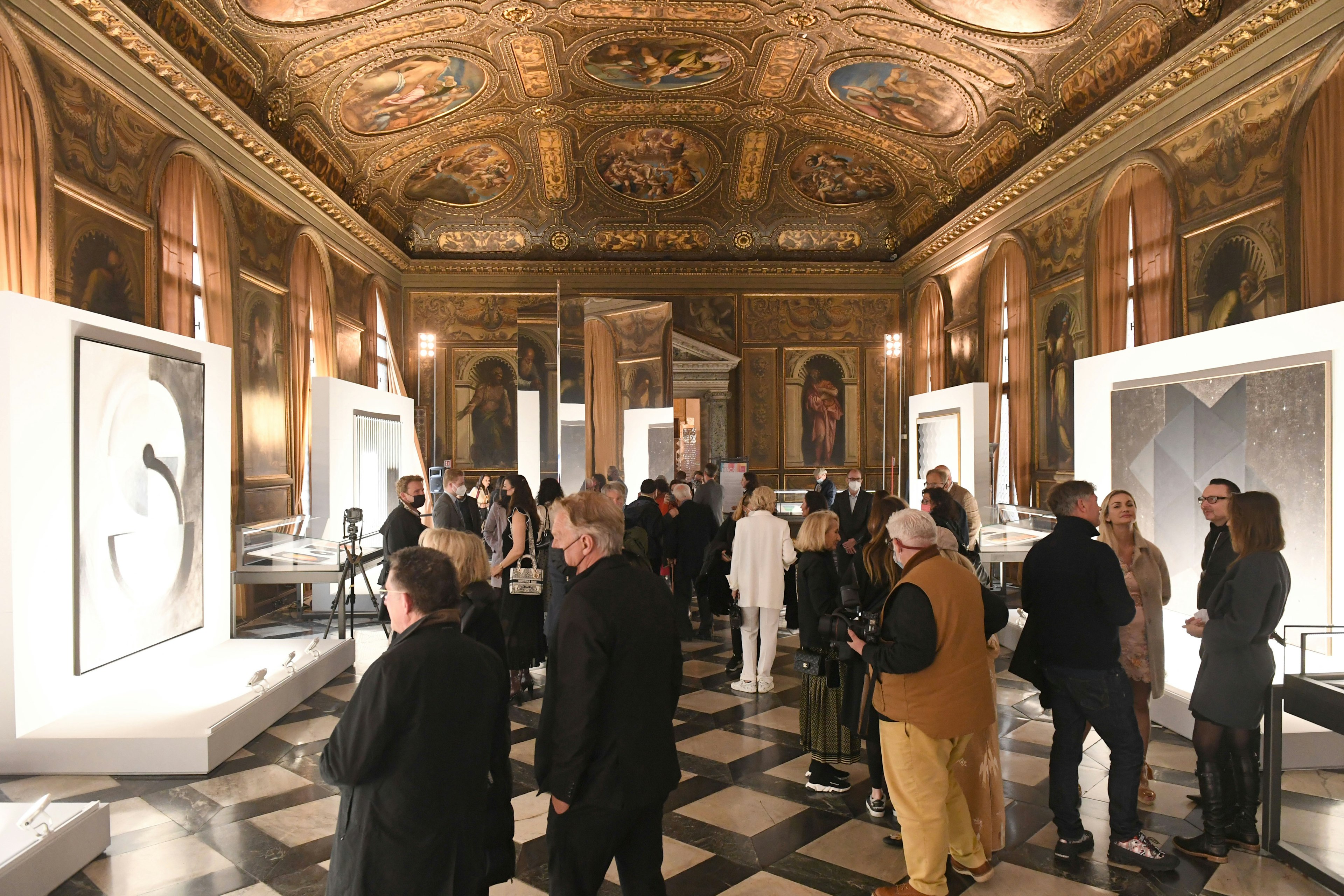 Guests stand before the opening an art exhibition in the reading room of the Renaissance Biblioteca Nazionale Marciana, Venice, Veneto, Italy