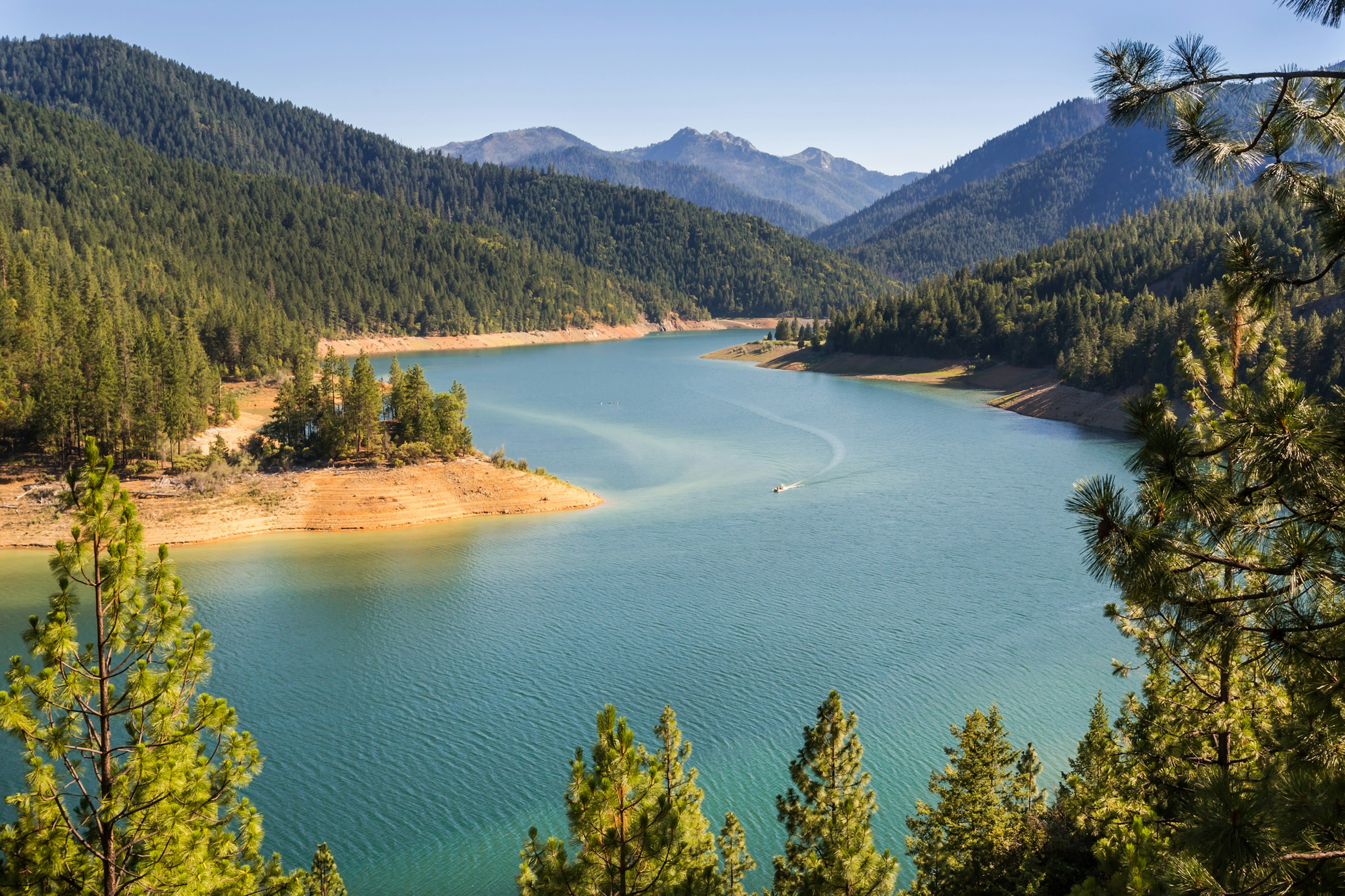 Beautiful naturally framed by pine trees landscape of the Applegate lake in Oregon, in golden hour.