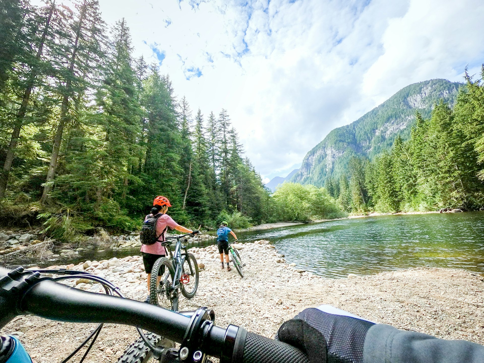 A family on their bicycles beside a rocky stream near the Seymour River, North Vancouver, British Columbia, Canada